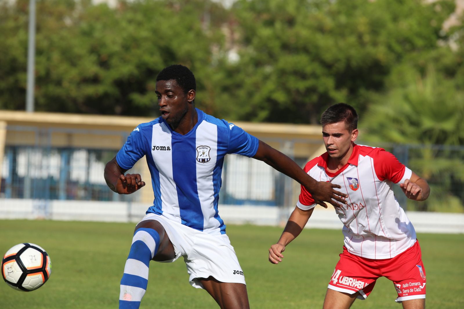 Pascu cubre el balón ante la presión de un futbolista del Ubrique.