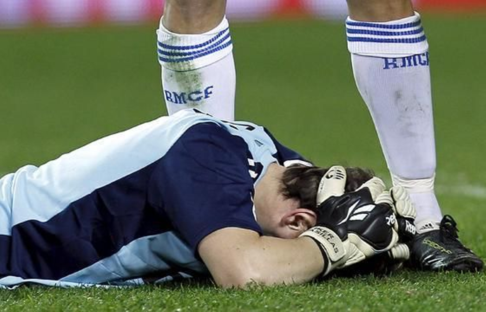 Casillas se queda tumbado en el suelo tras recibir un botellazo lanzado desde la grada al final del partido. / EFE