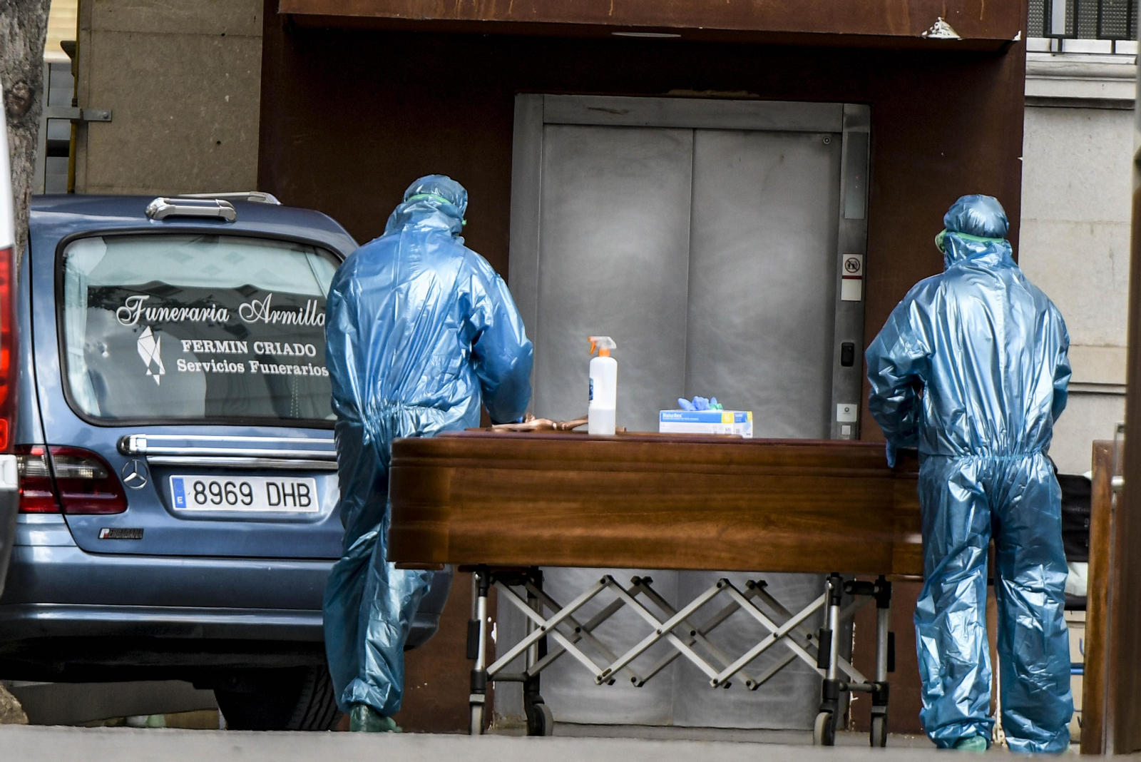 Trabajadores de una funeraria equipados con un EPI sacan un féretro de un hospital de Granada la pasada primavera