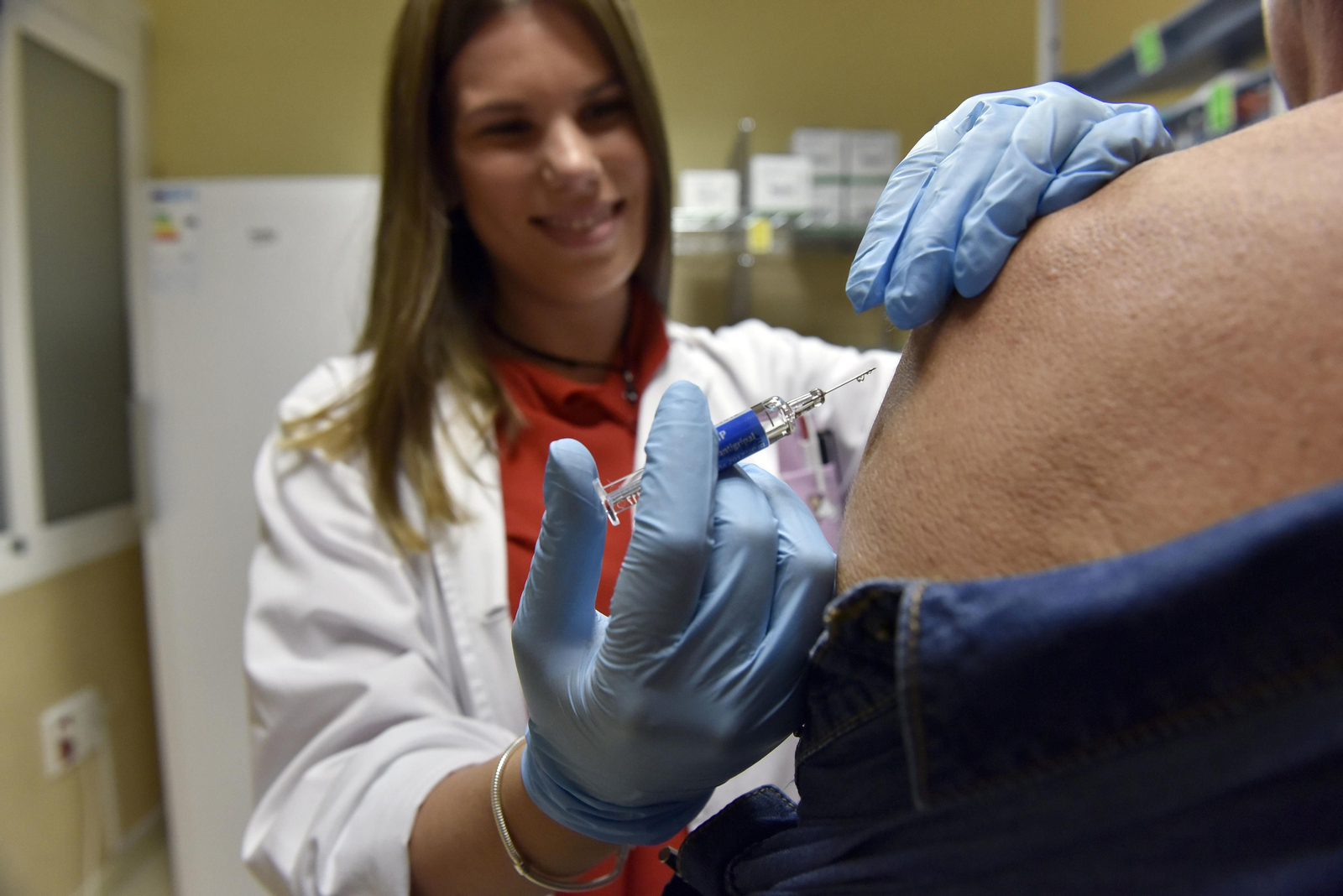 Una enfermera administra la vacuna de la gripe a un paciente.