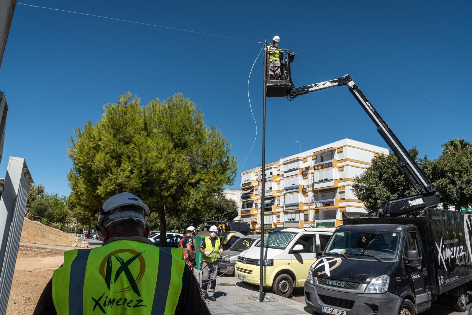 Varios trabajadores de Iluminaciones Ximénez colocan el cableado que soportará las luminarias en un poste de la avenida Diego Morón de La Orden.