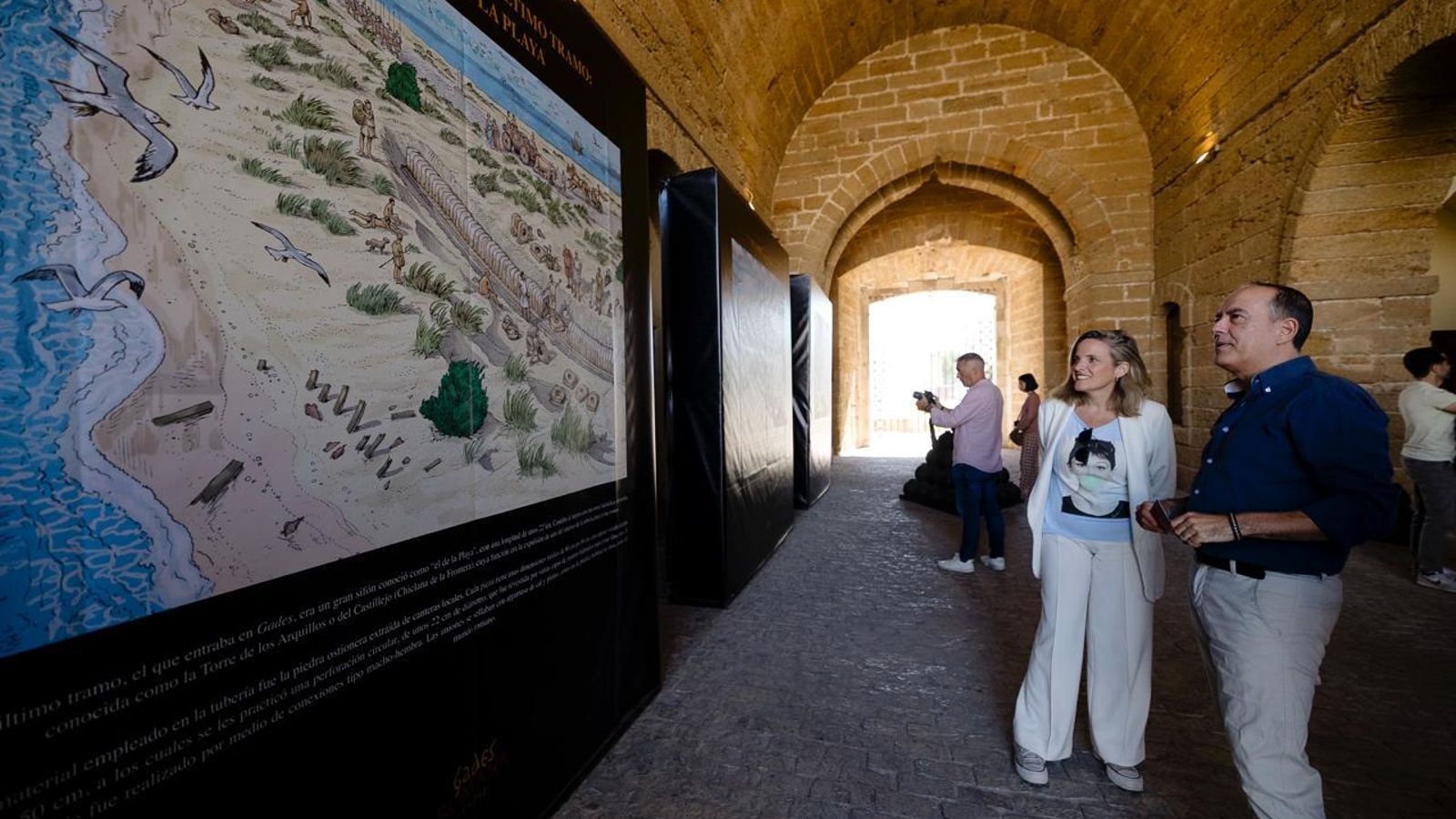 El ilustrador Arturo Redondo y la edil Maite González, en la entrada del torreón de las Puertas de Tierra durante la inauguración de 'La calzada y el acueducto de Gade3s'.