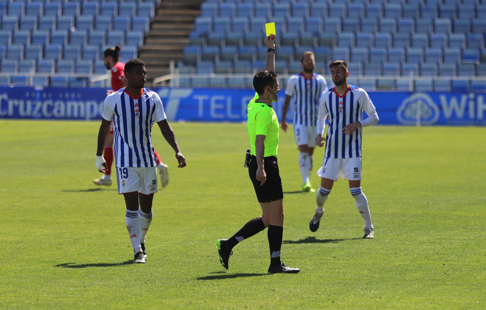 Roberto Carralero muestra una cartulina amarilla en su último partido en el Nuevo Colombino.
