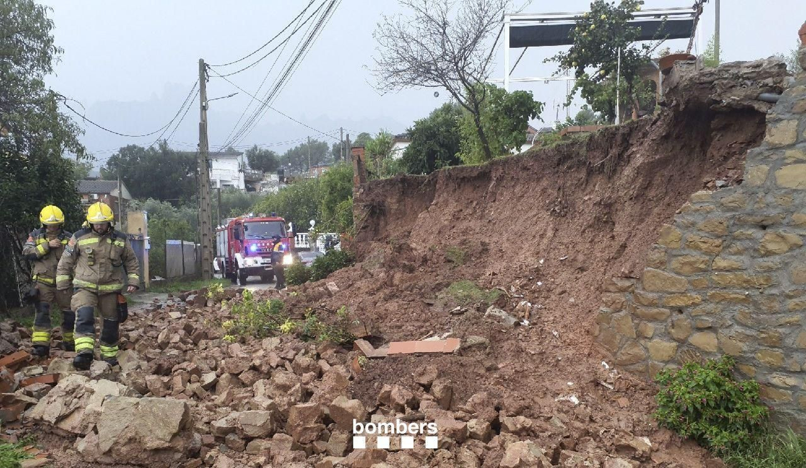 Los bomberos trabajan en un desprendimiento de tierras en Marganell por las intensas lluvias de este domingo en Cataluña.