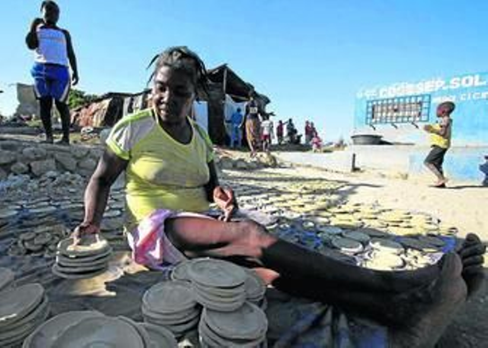Una mujer vende galletas de lodo en un descampado de Cité Soleil.
