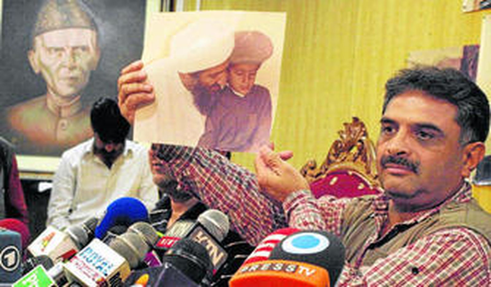 El periodista paquistaní Mazhar Ali Khan muestra ayer una foto de Ben Laden y su hijo tomada en Tora Bora en el año 1999.