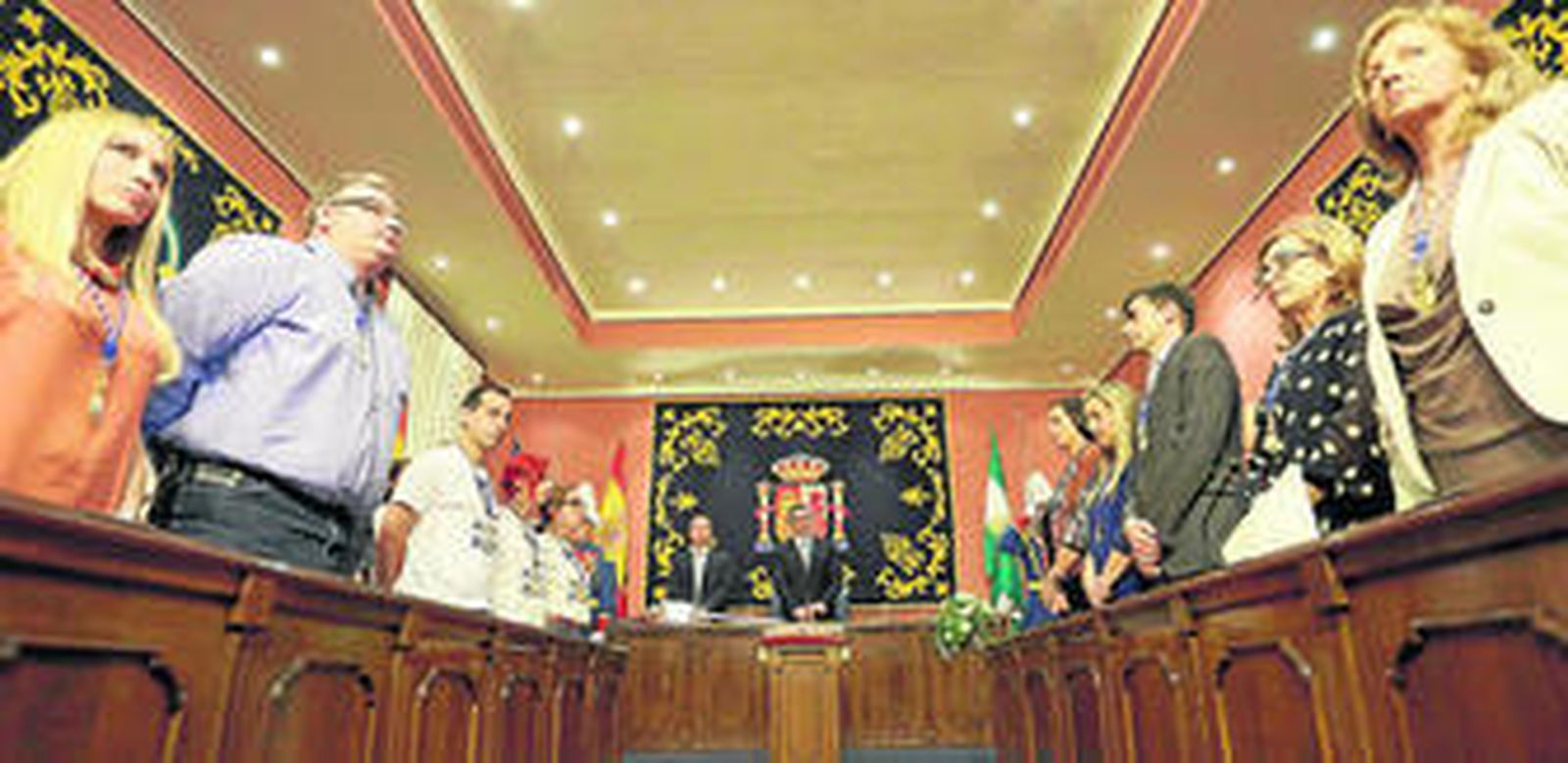 Los concejales del nuevo plenario de Alcalá, de pie y serios, cuando tras la investidura de Gutiérrez Limones se escucharon los himnos andaluz y nacional.
