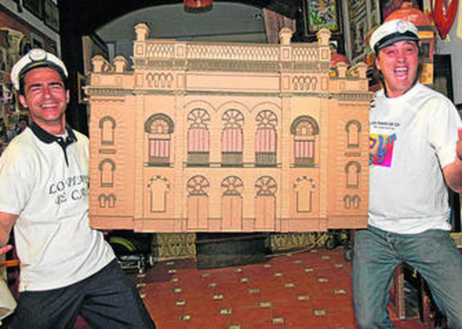 Juan Vargas y Juanlu 'Cascana' sostienen una maqueta del Falla vestidos como pimpis.