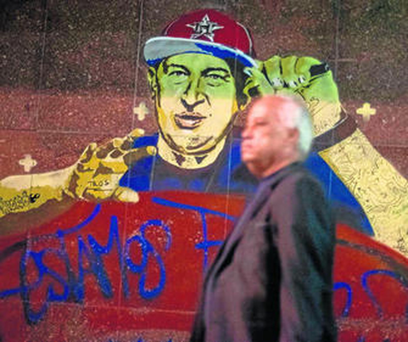 Un hombre pasa en Caracas ante un retrato del presidente venezolano, Hugo Chávez.