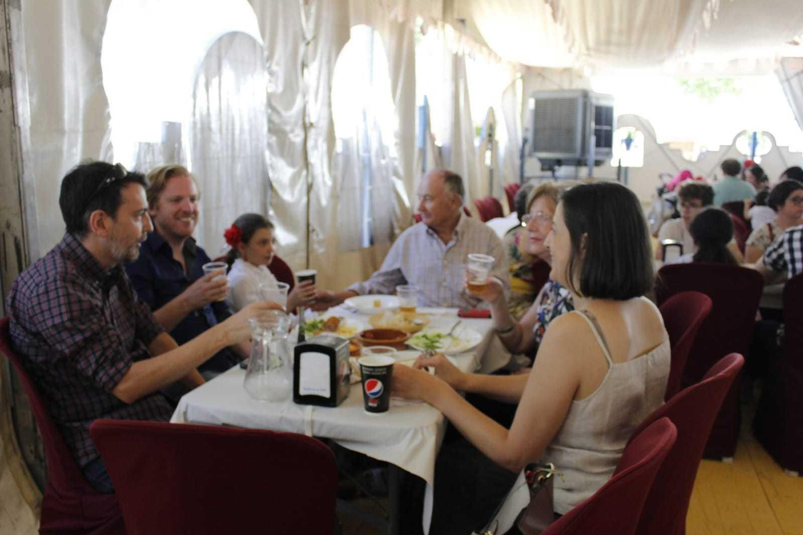 Una familia disfruta de una comida en una de las casetas de la Feria.