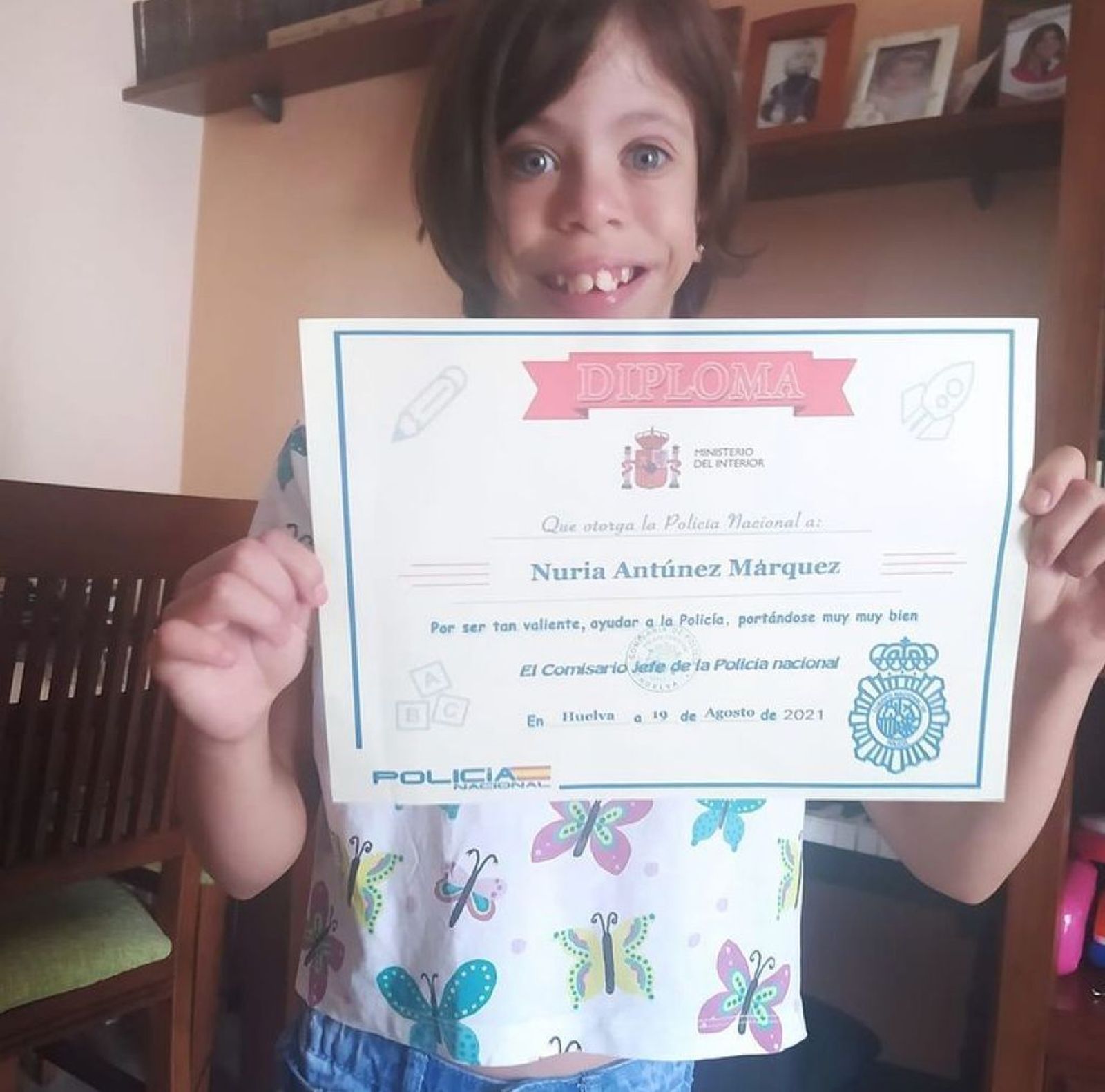 La  protagonista de la historia posa feliz con el diploma entregado por los agentes.