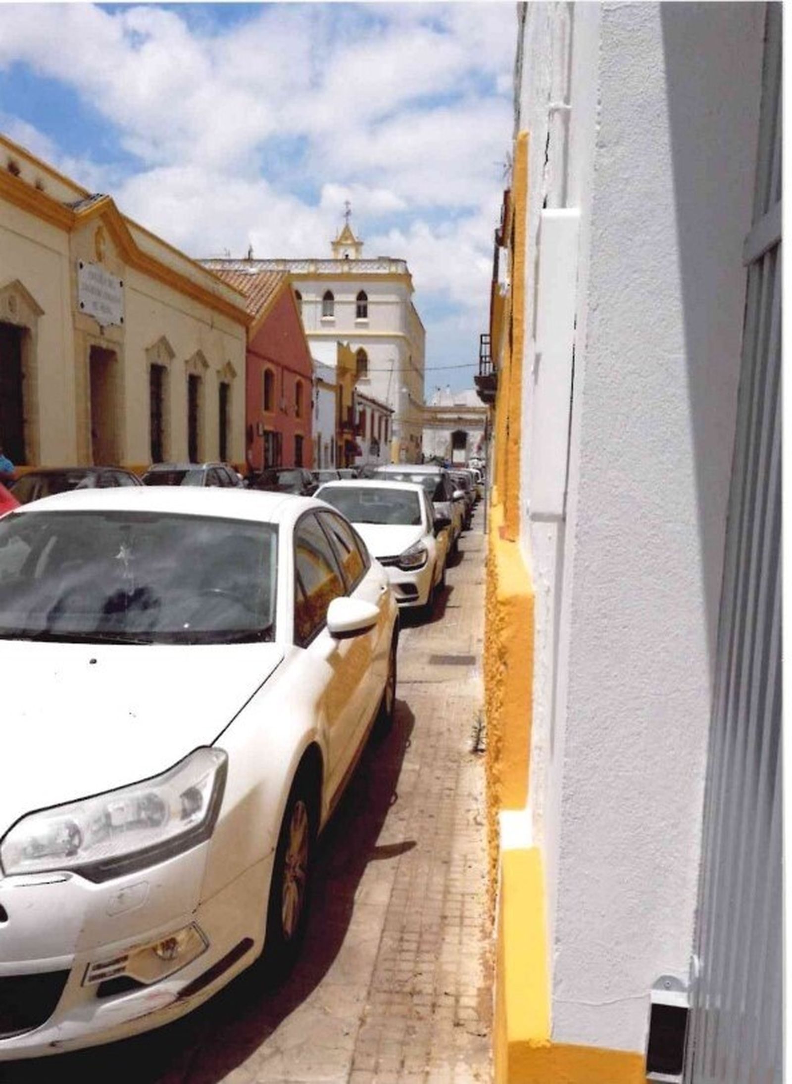 Otra imagen de coches sobre la acera de toda la calle.