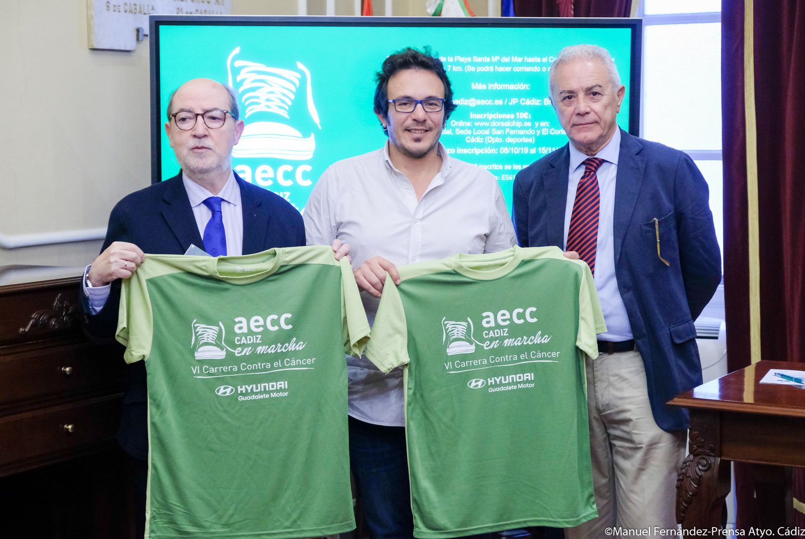 De izquierda a derecha, Ignacio Moreno, el alcalde de Cádiz y Manuel Jiménez con la camiseta de la carrera.