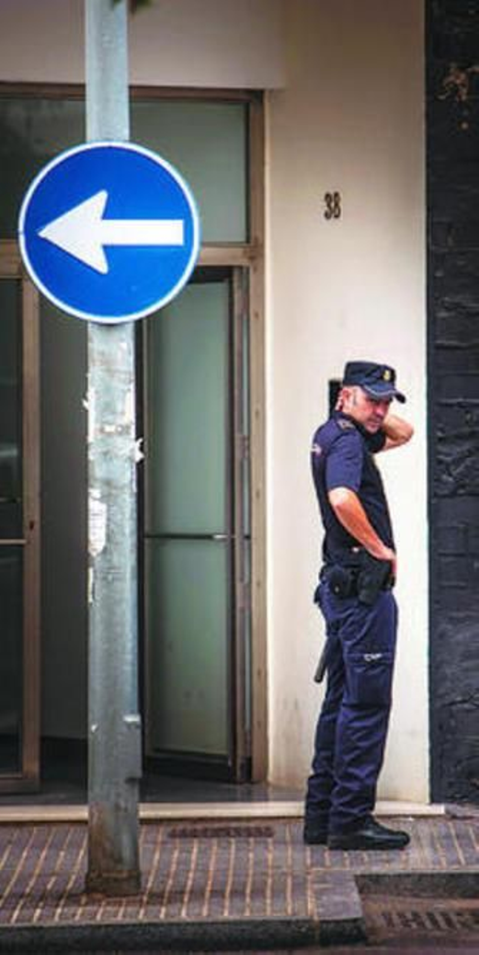 Un agente de Policía en el portal del número 38 de la avenida de Portugal.