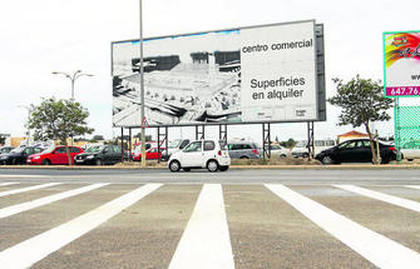 Un cartel de grandes dimensiones en La Longuera sigue ofreciendo superficies en alquiler en el centro comercial, siete años después.