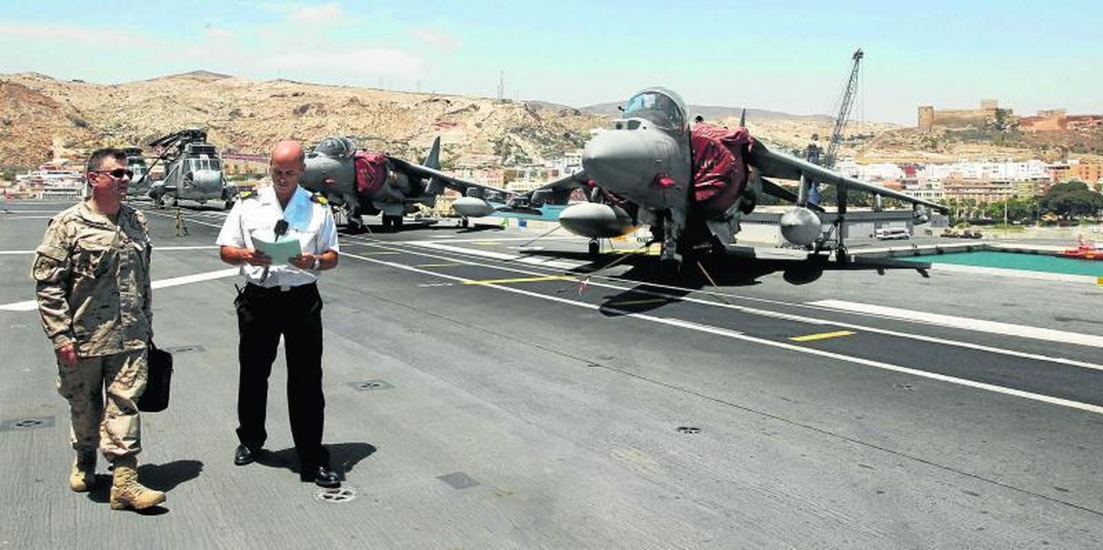 Oficiales del Grupo de Acción Naval 2 y del 'Tercio de Armada' junto a varios de los aviones Harrier que operan desde el buque anfibio de asalto Juan Carlos I.