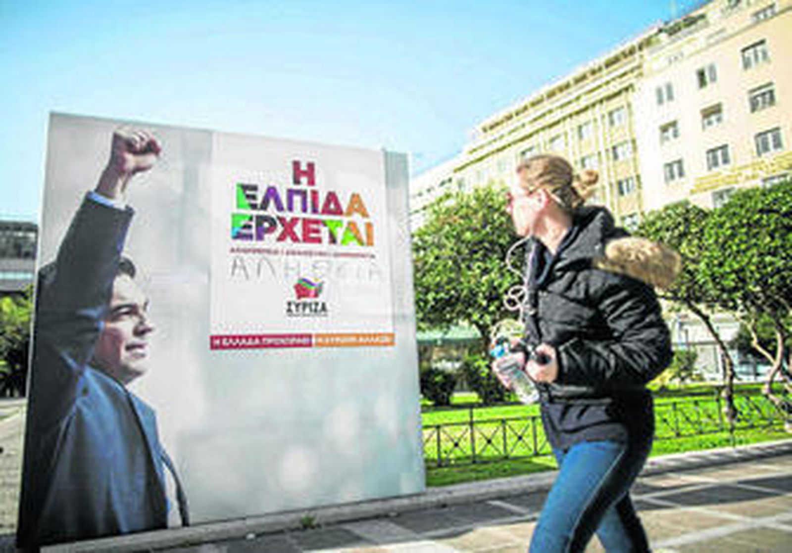 Una joven observa un cartel electoral del líder de Syriza, Alexis Tsipras, ayer en el centro de Atenas.