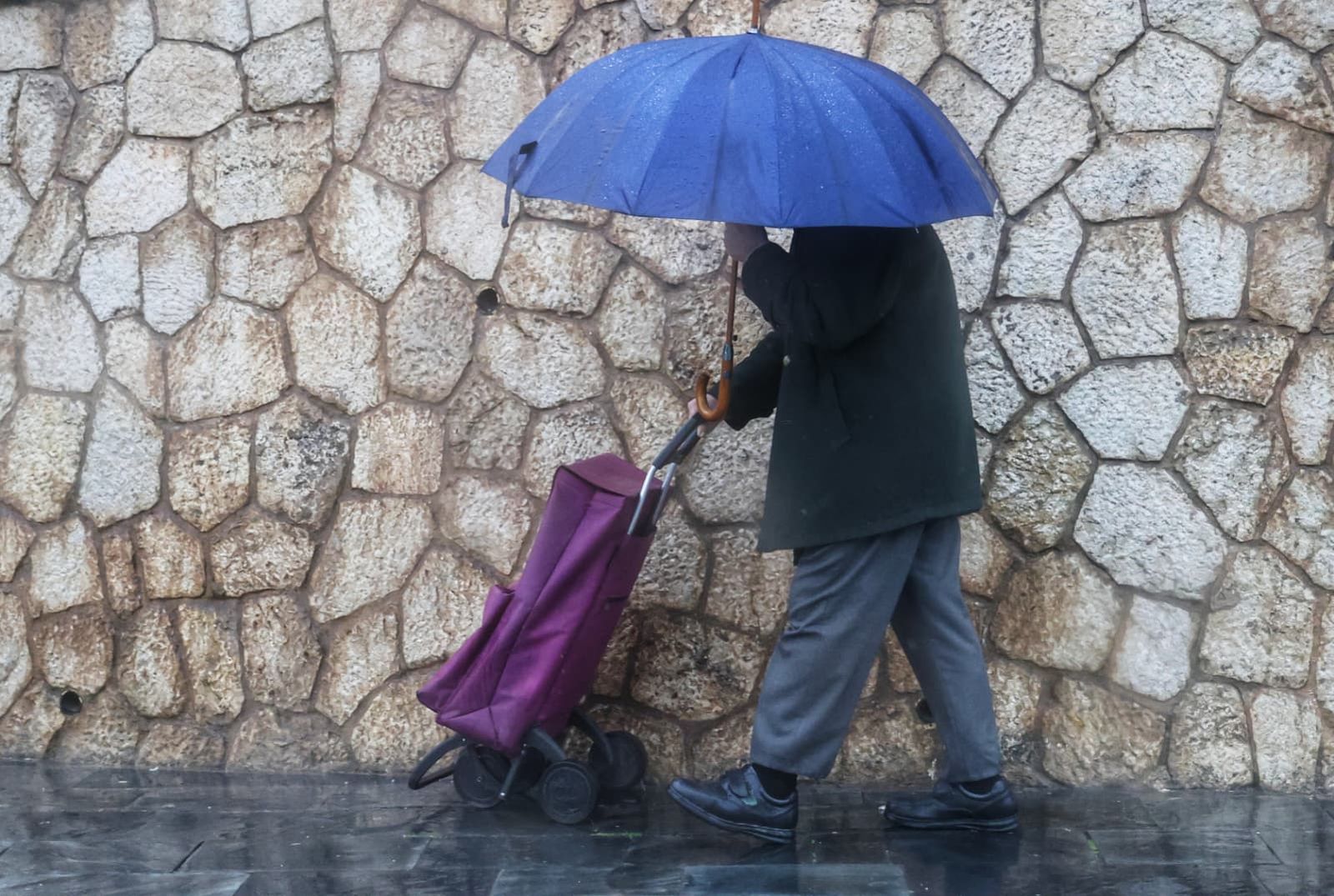 Una persona se protege de las lluvias en Málaga con un paraguas.