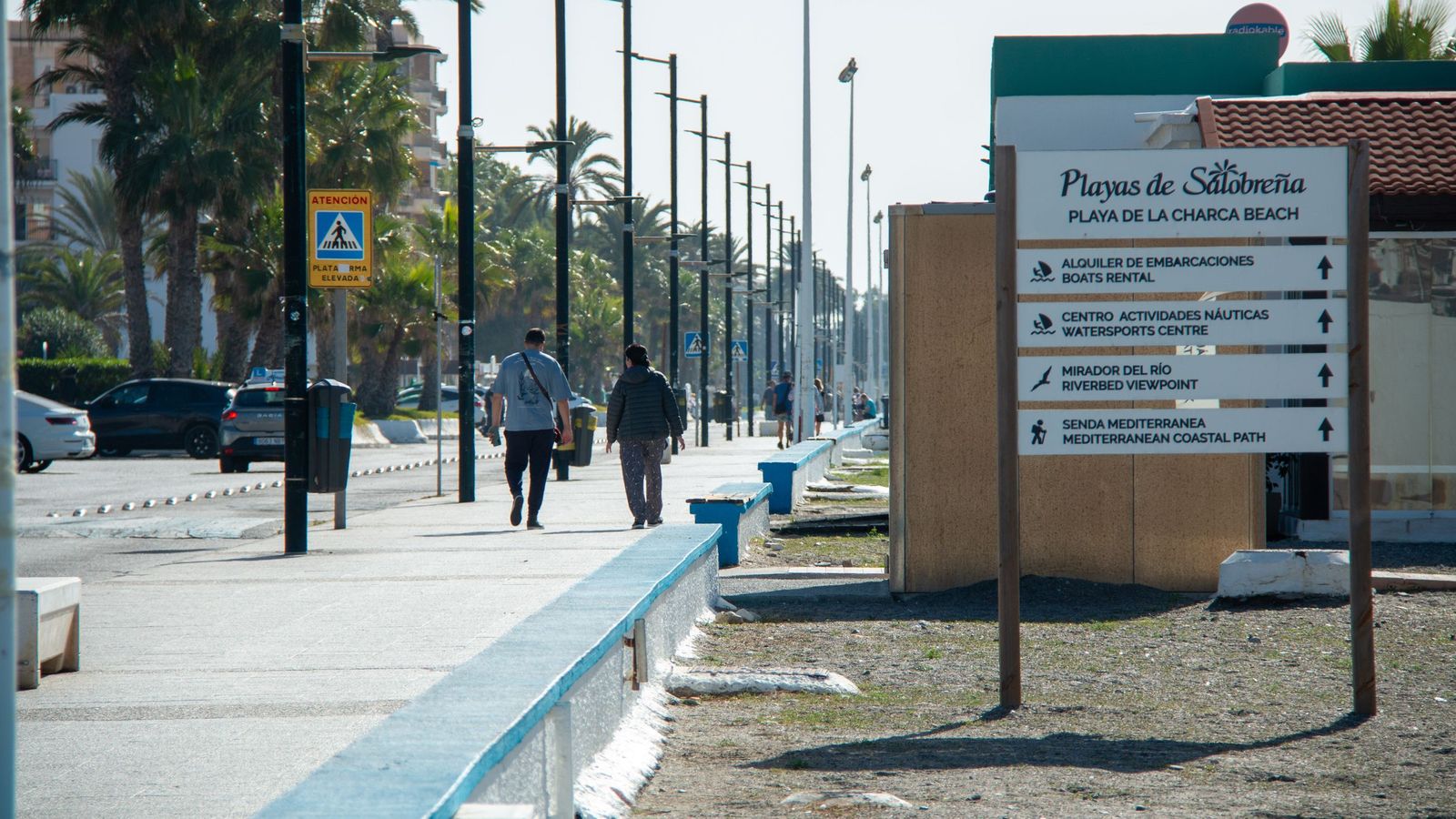 Varias personas caminan por el paseo marítimo de Salobreña