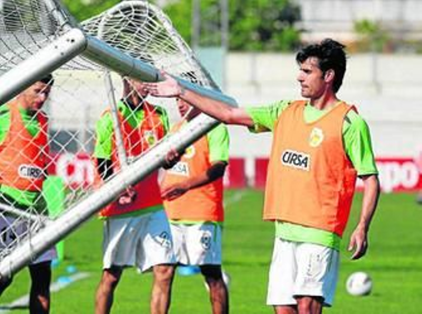 Chechu Dorado ayuda a transportar una portería en un entrenamiento.