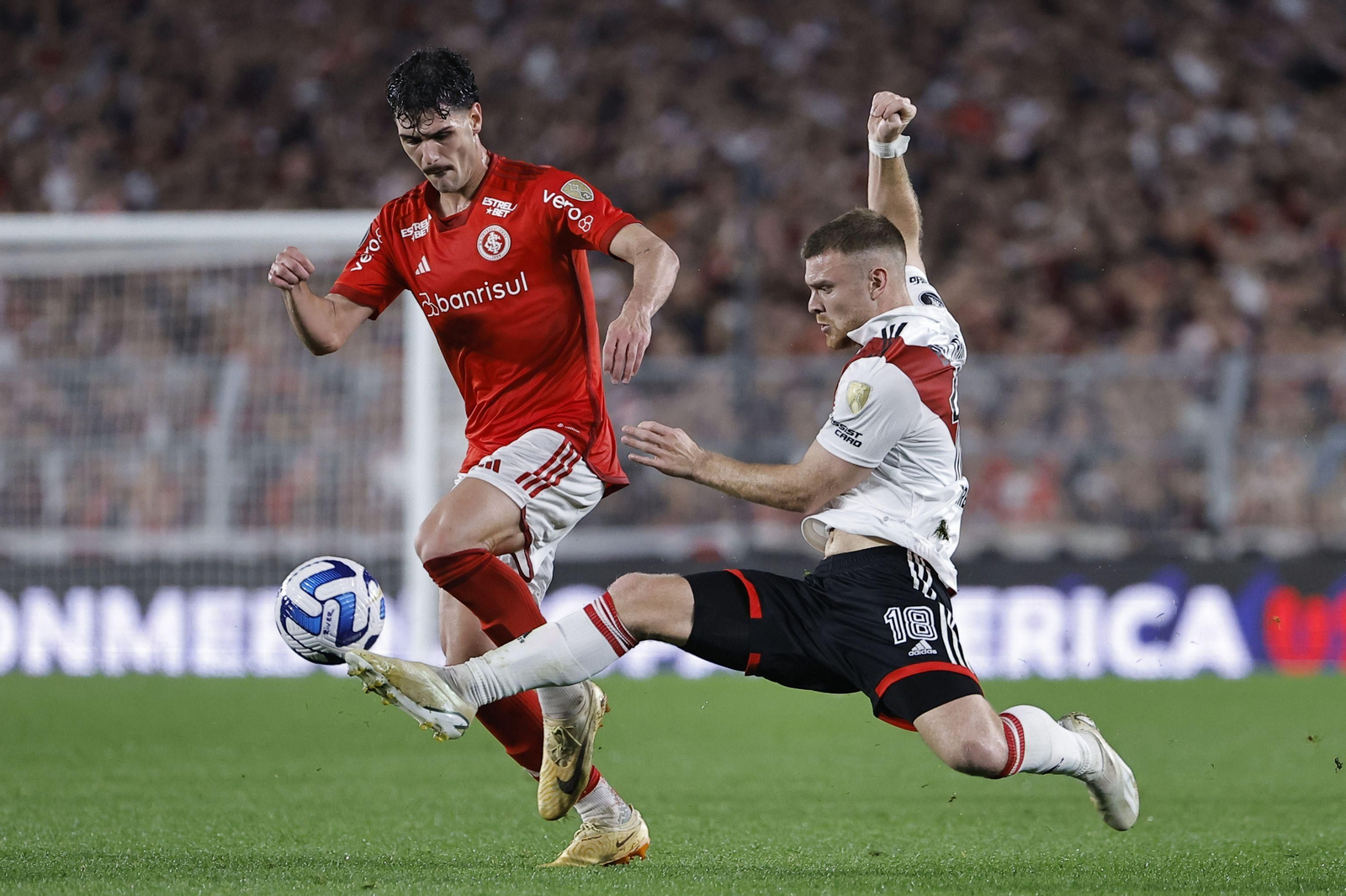 Johnny  Cardoso,  de Internacional, disputa un balón con  Lucas Beltrán, de River Plate.