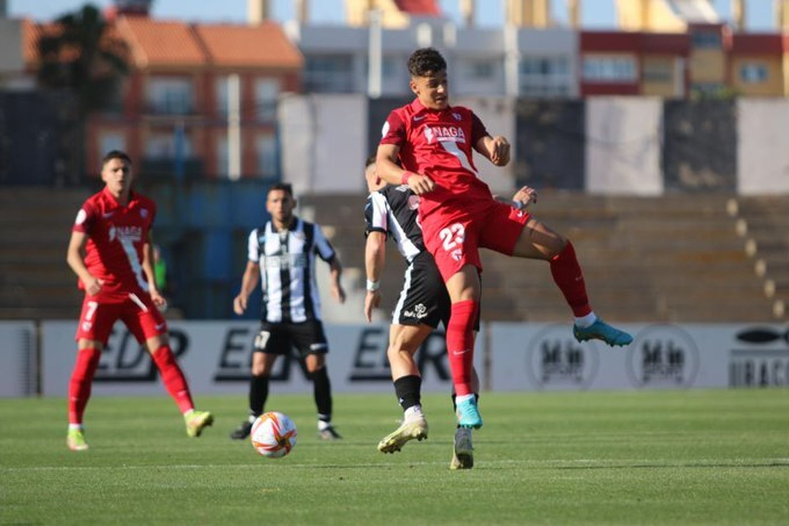 Juan María salta por un balón en la reciente visita al Linense, al que podría adelantar de nuevo el filial.