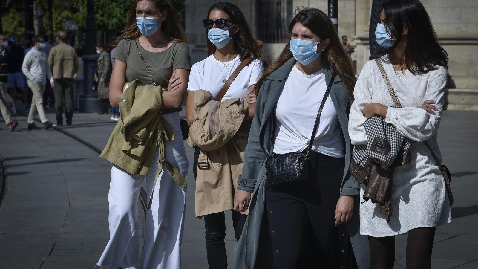 Cuatro jóvenes con sus mascarillas, por el centro de Sevilla.