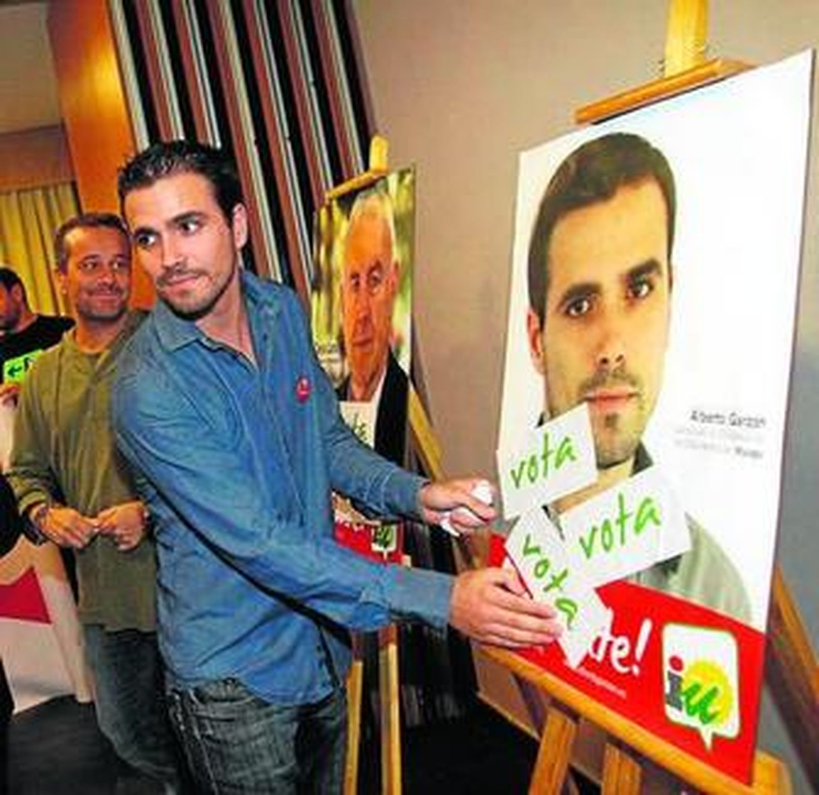 Alberto Garzón en la simbólica pega de carteles anoche.