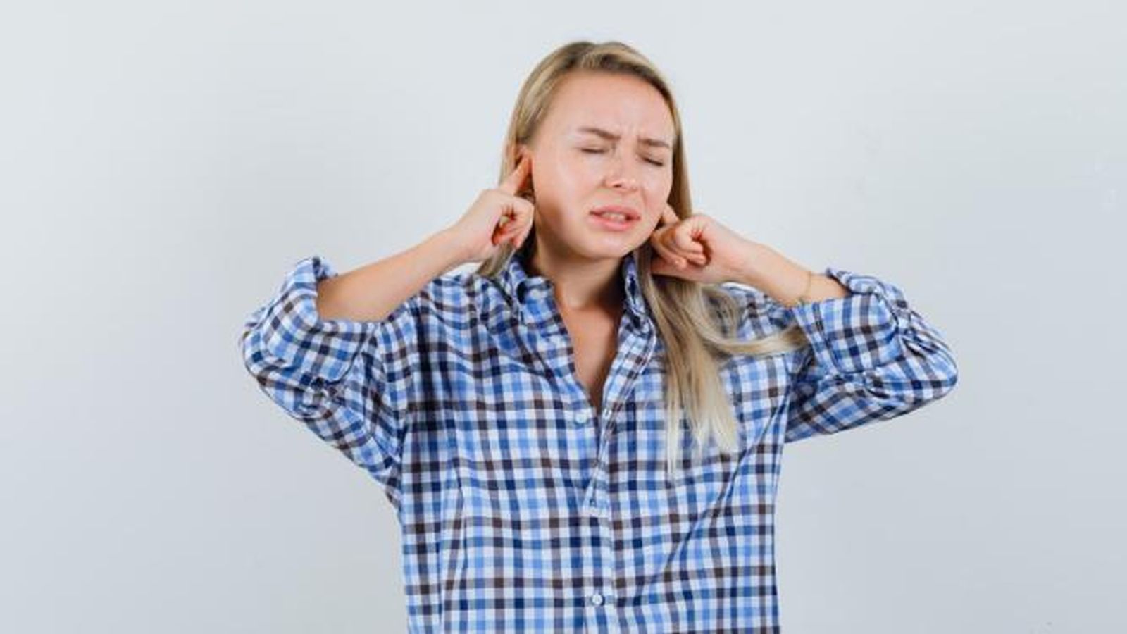 Mujer tapándose los oídos.