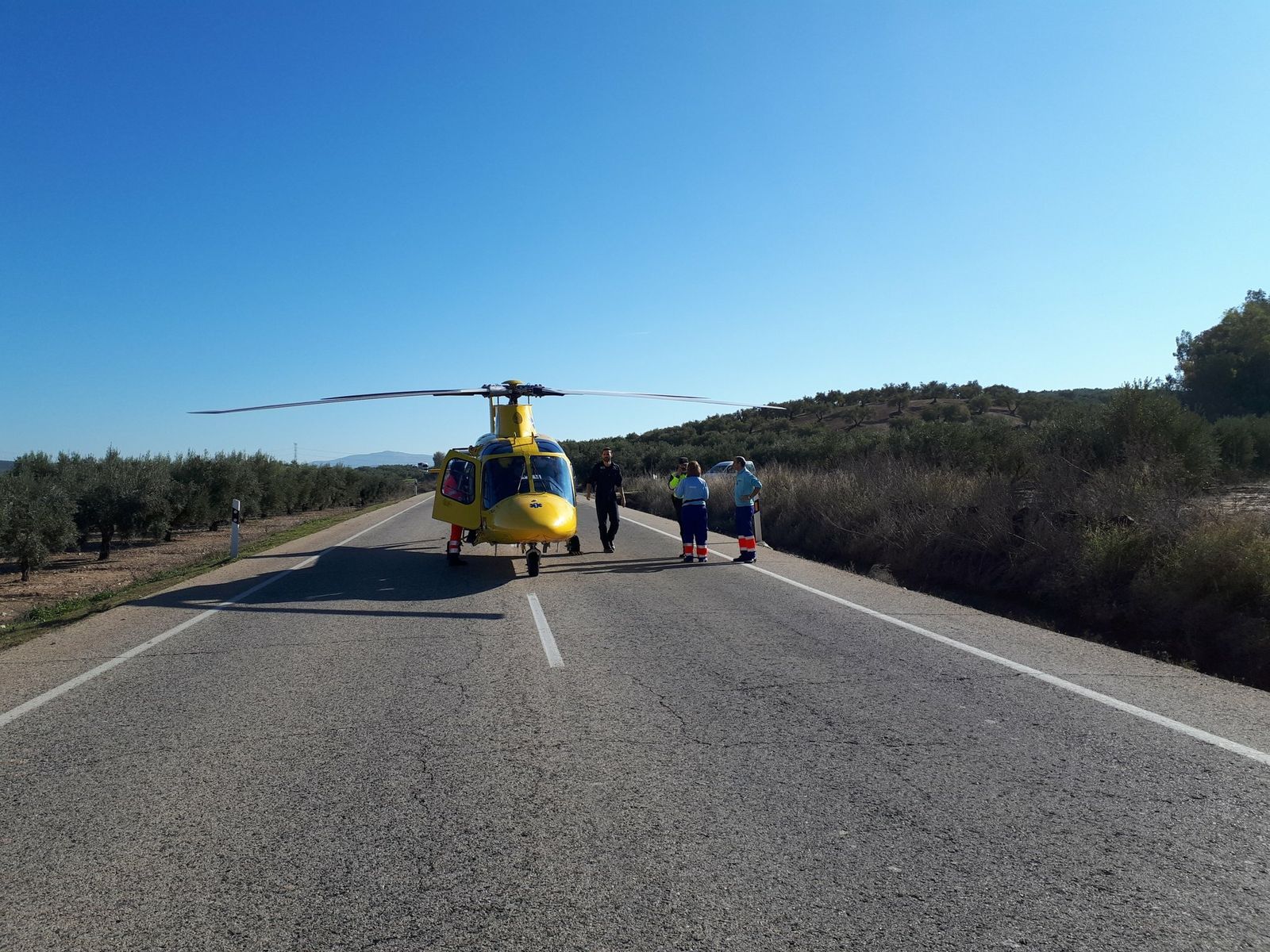 El helicóptero sanitario, en la N-432, donde aterrizó para recoger al ciclista.