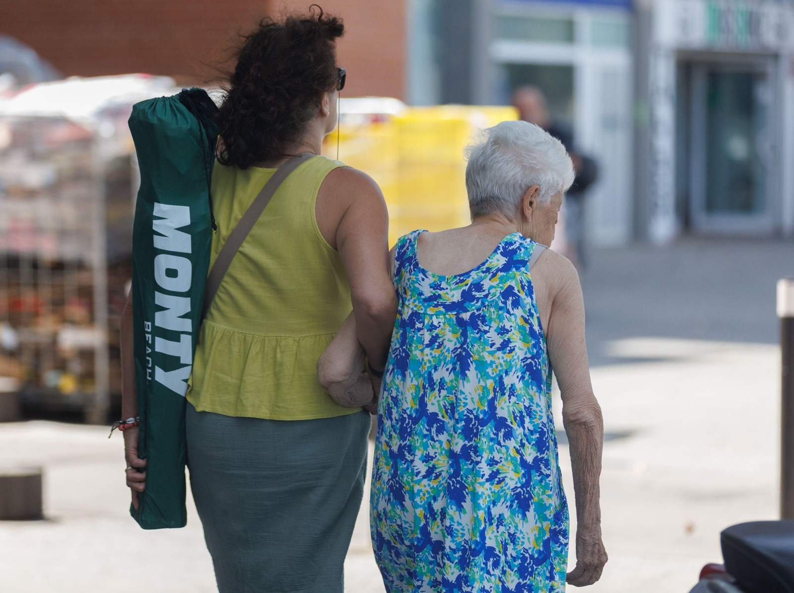 Una señora mayor pasea con un familiar por las calles de Cádiz