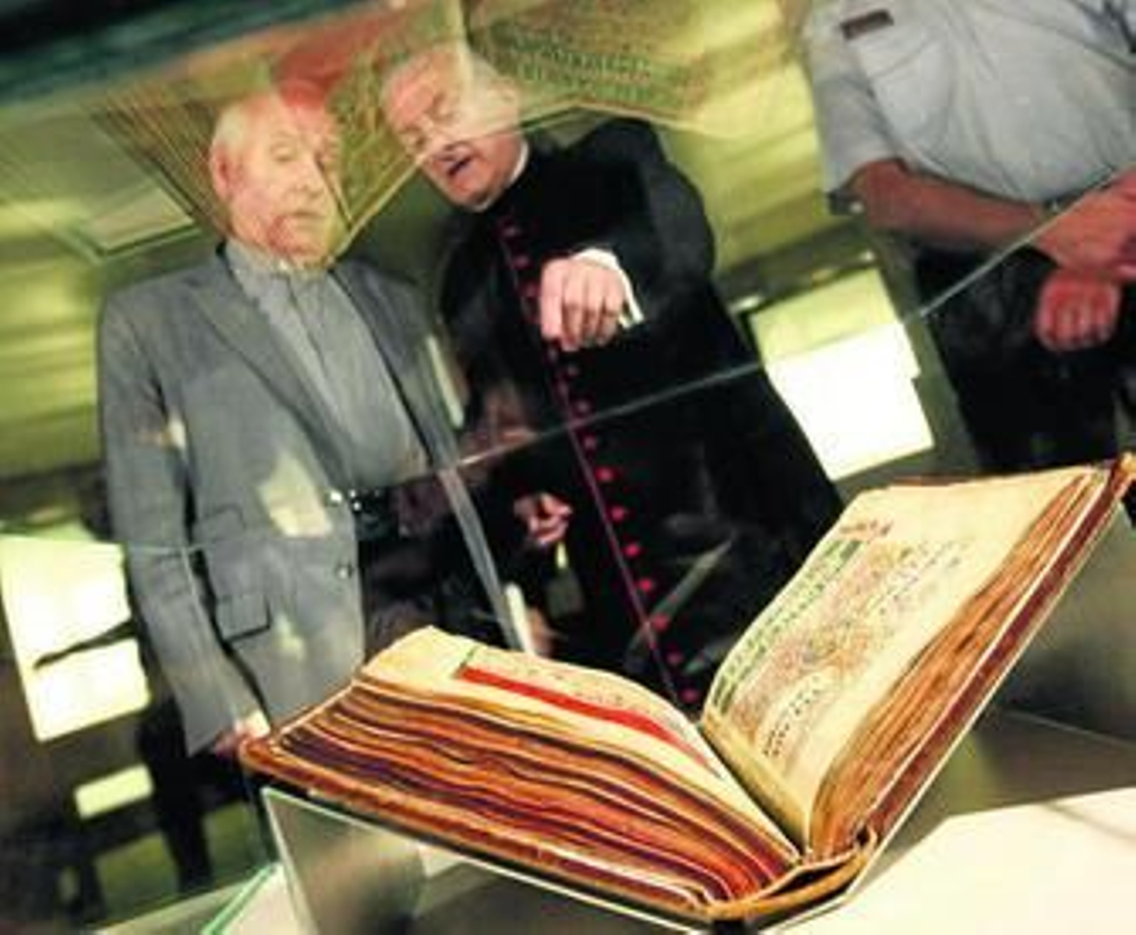 El deán de la Catedral comenta con el archivero Segundo Pérez el contenido de la muestra.