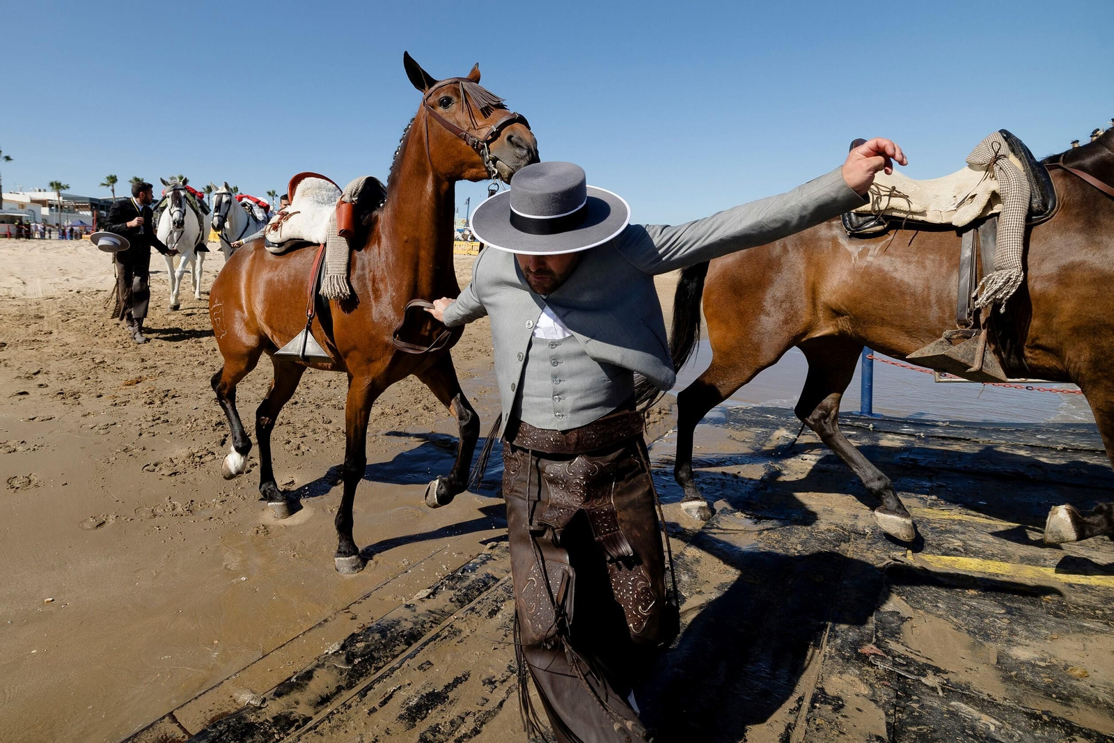 Un romero de Sanlúcar atraviesa el río con sus caballos.
