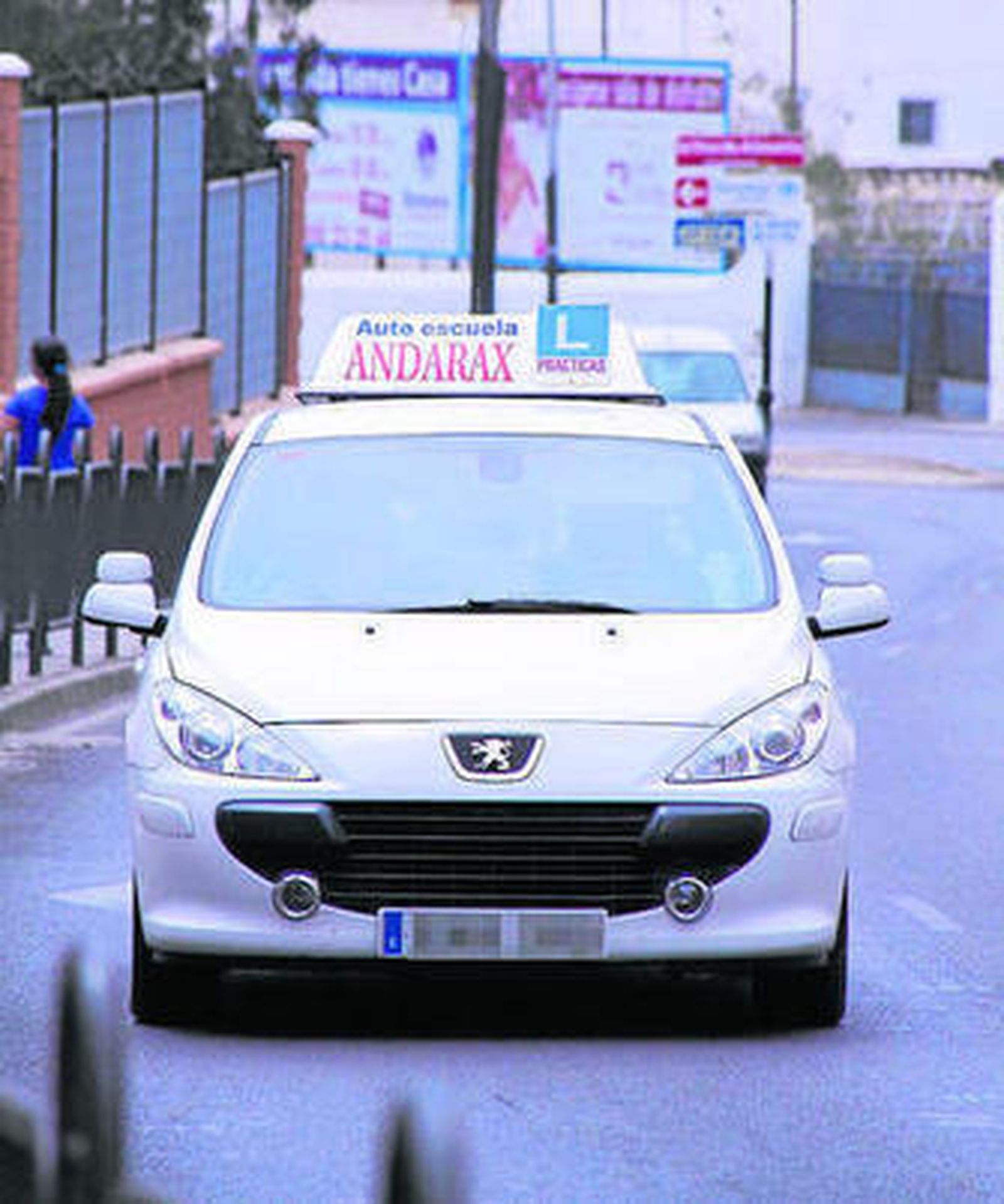 Un coche de una autoescuela realizando sus prácticas por la ciudad.