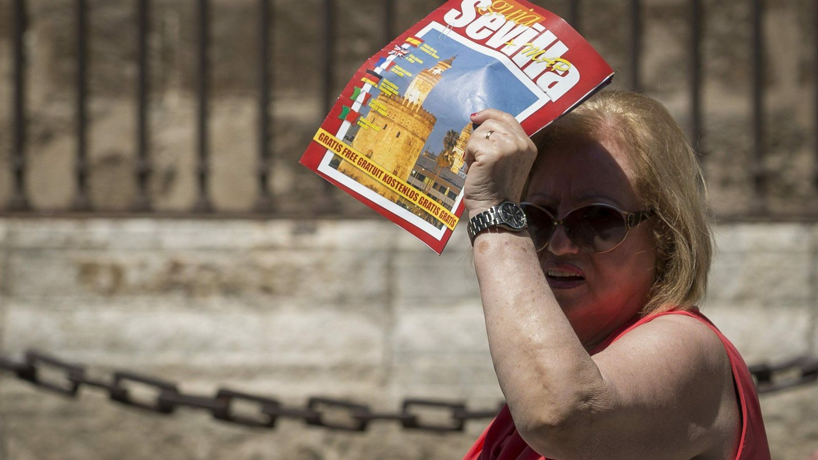 Mujer protegiéndose del sol con una revista