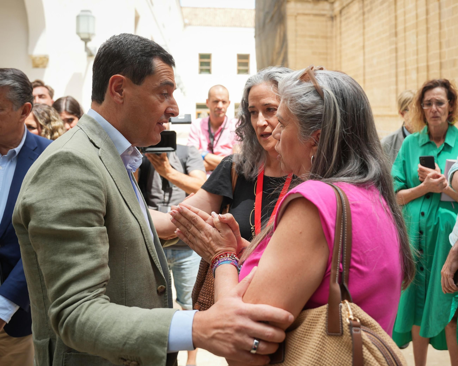 El presidente de la Junta, Juanma Moreno, hablando en el patio del Parlamento con las madres que piden cuidados paliativos pediátricos.