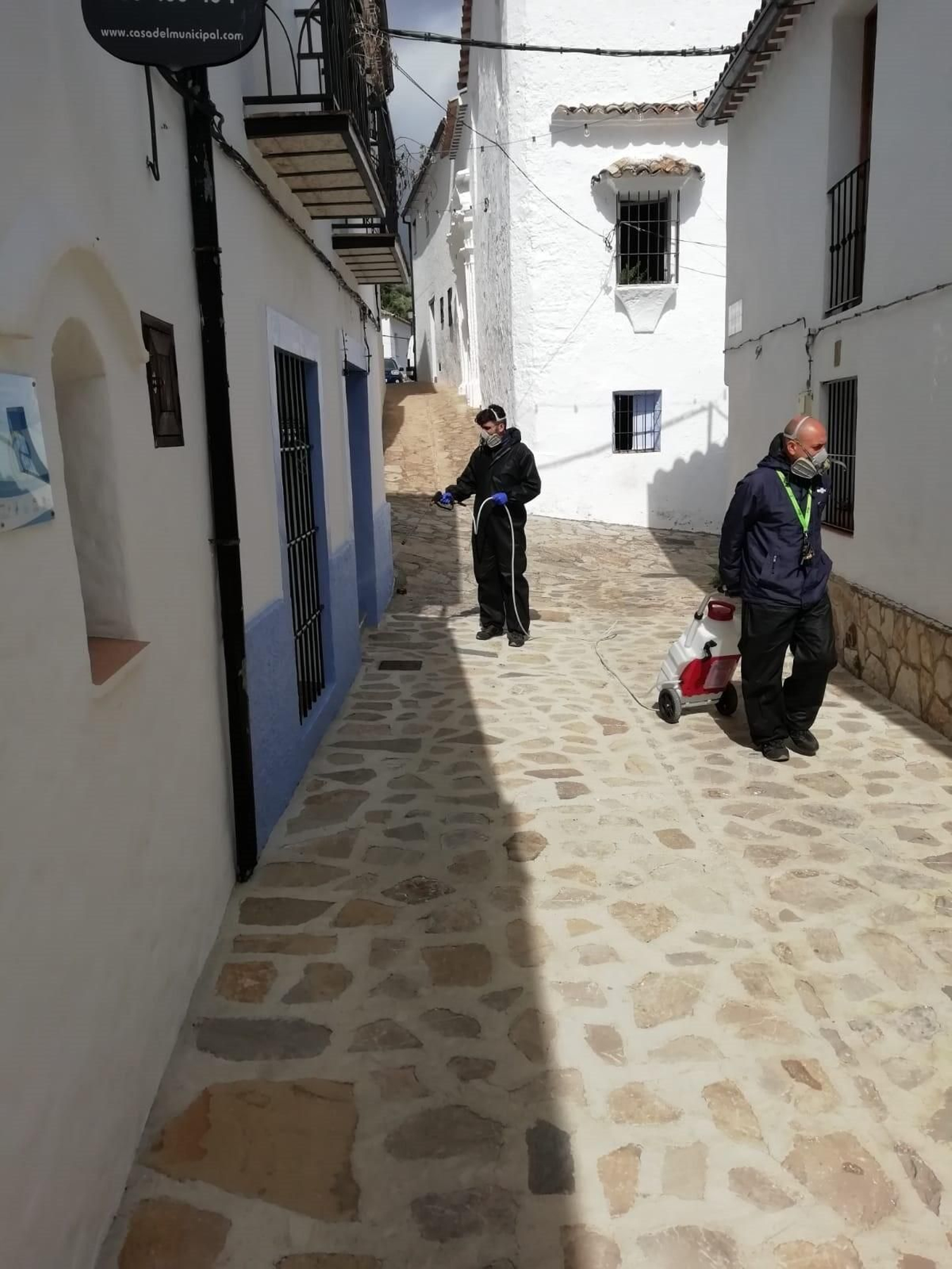 Varios operarios desinfectando las calles del pueblo.