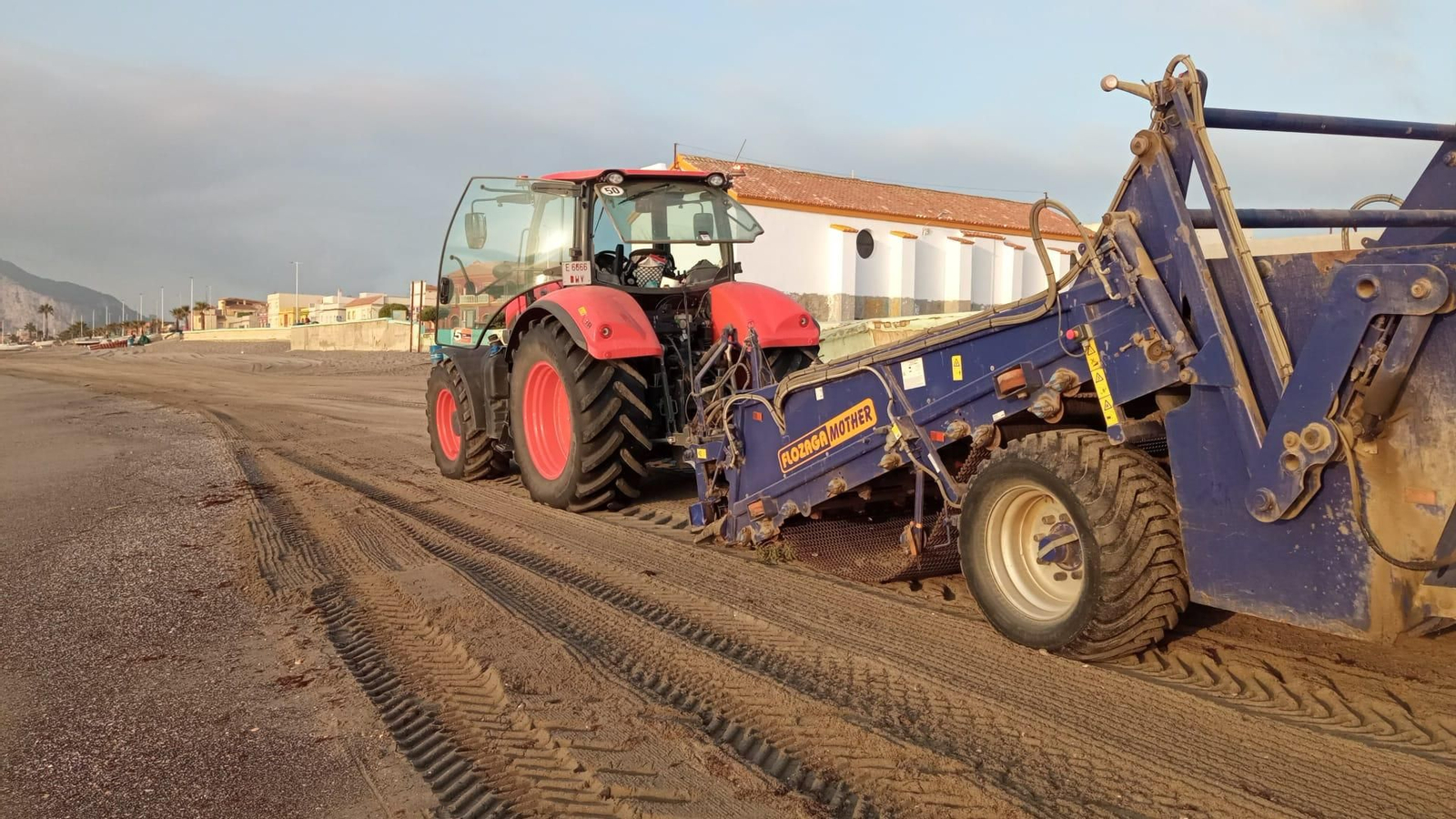Un tractor limpia una de las playas de La Línea.