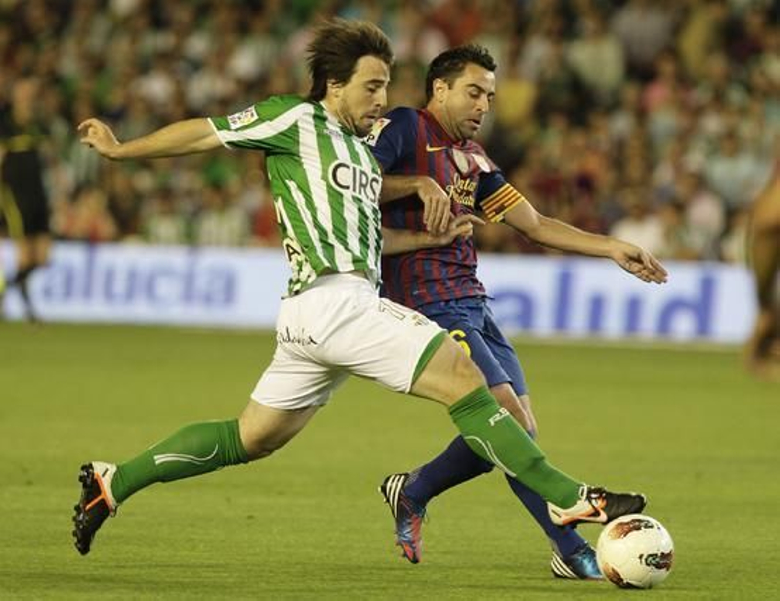 Beñat lucha un balón con Xavi. / A. Pizarro