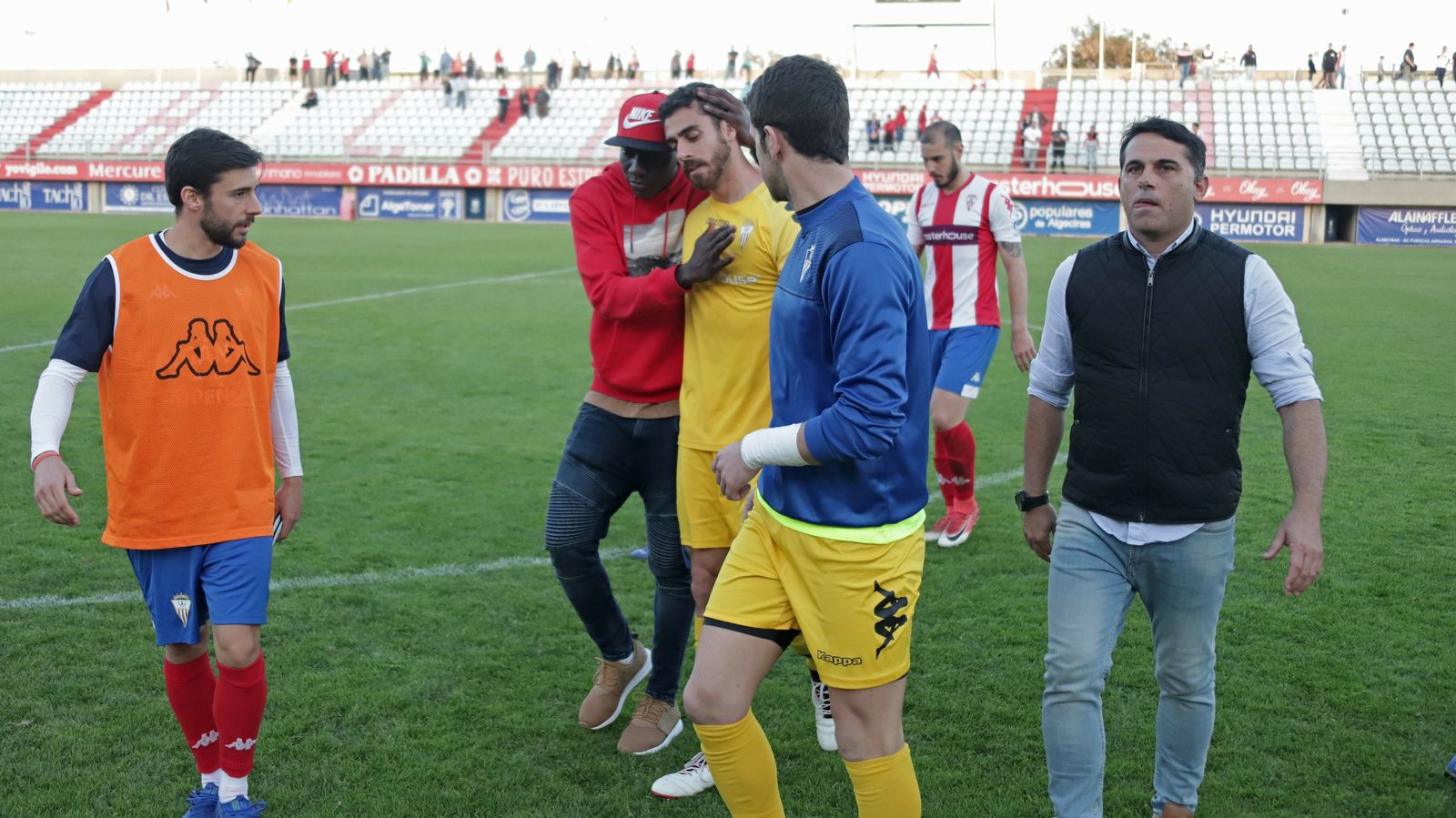 El portero del Algeciras Jesús Romero se marcha abatido y consolado por sus compañeros.