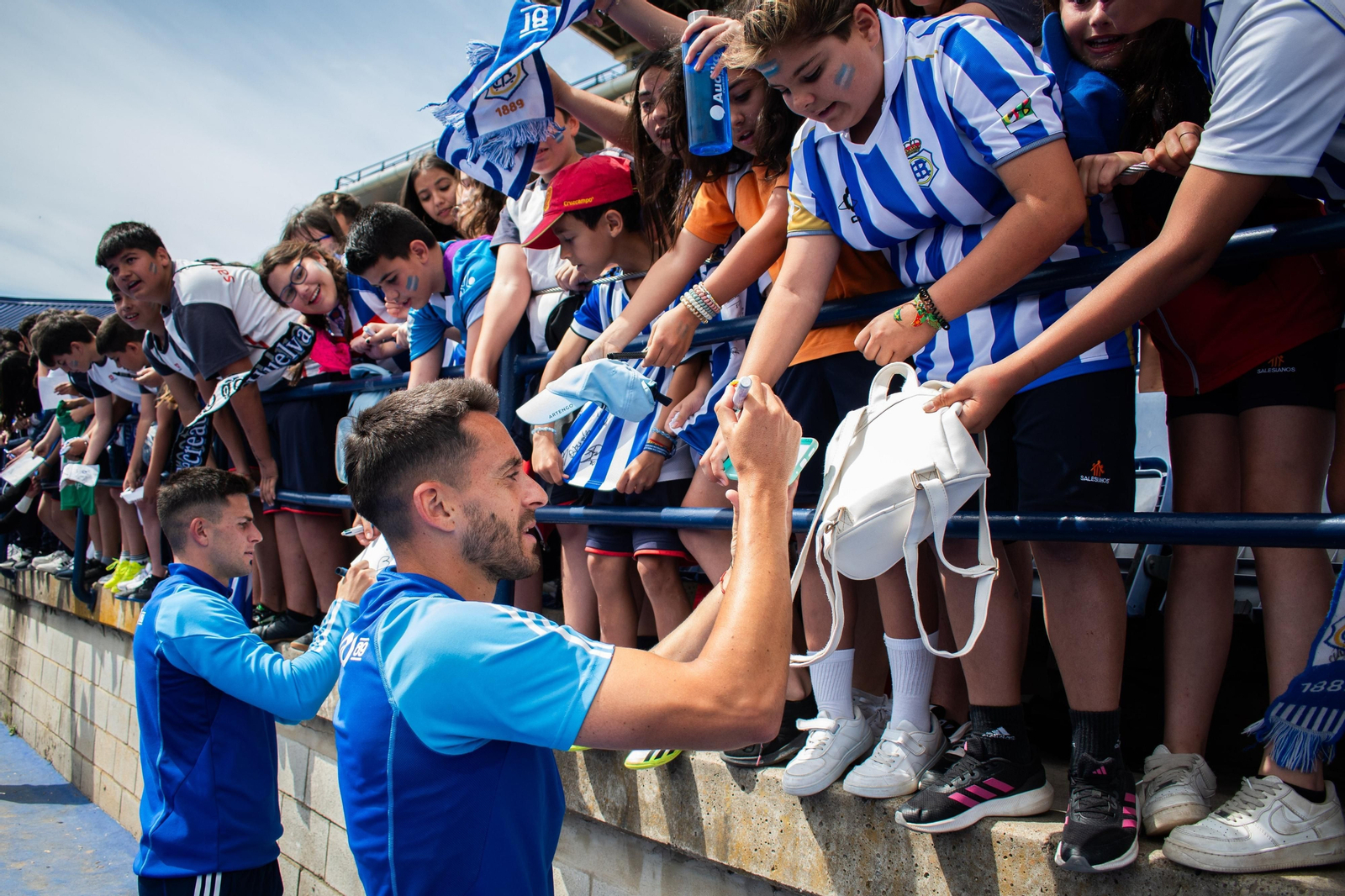 Iago Díaz y David del Pozo firman autógrafos a los asistentes al entrenamiento.