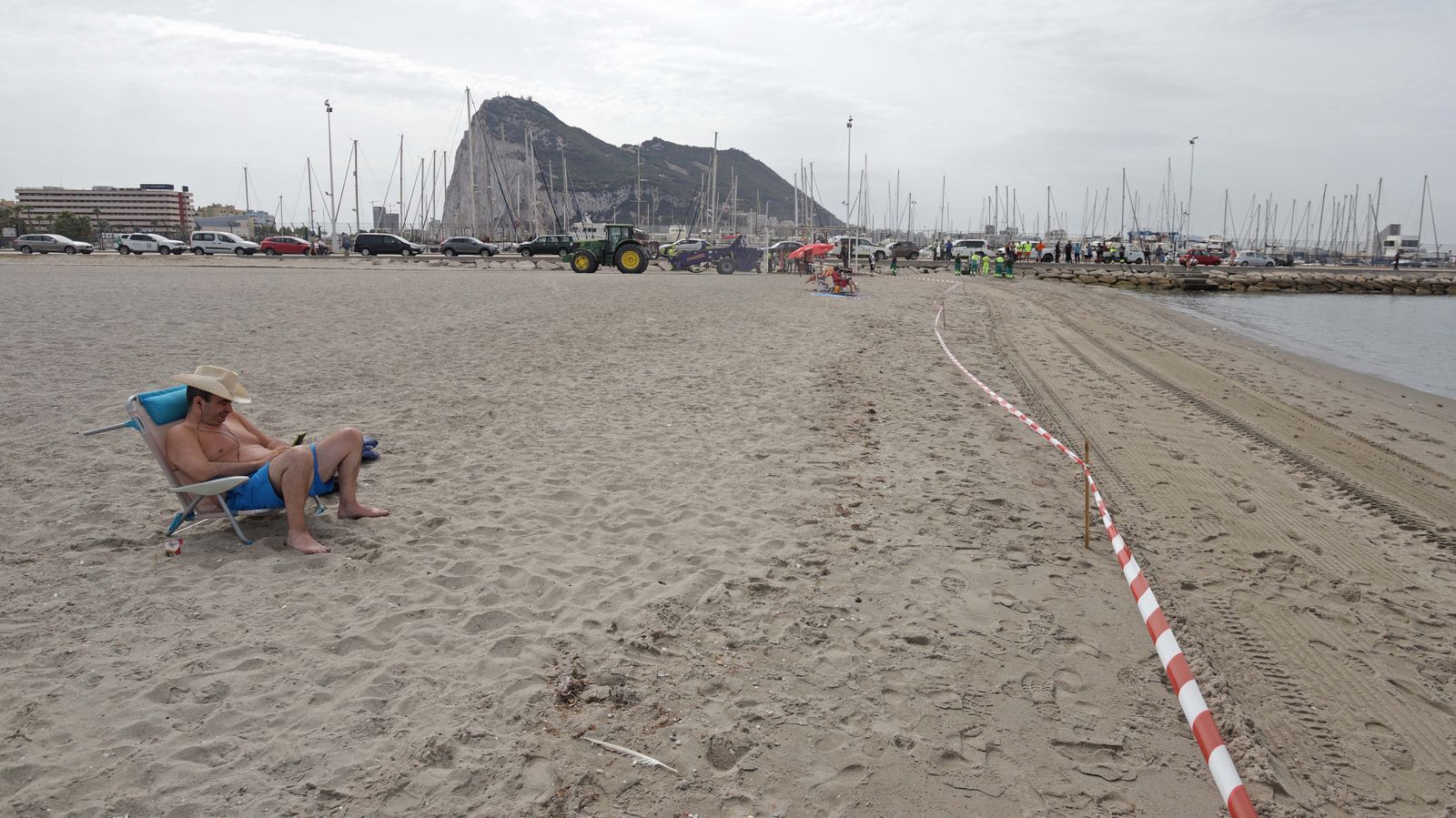 Un bañista en la playa de Poniente, justo delante de la barrera que prohíbe el baño.
