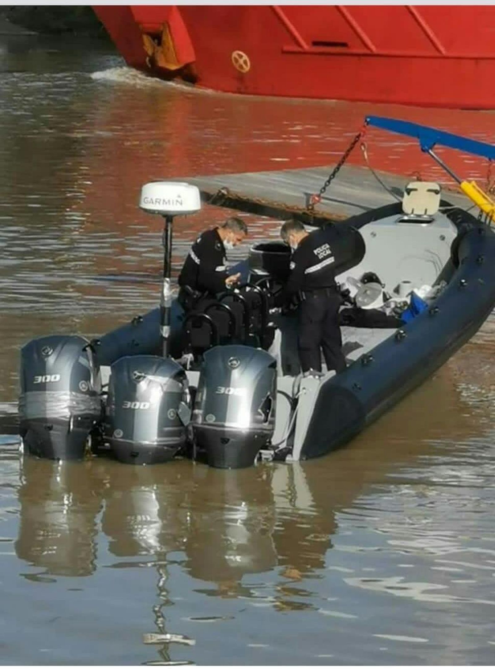 Dos policías locales de Coria del Río examinan la narcolancha intervenida.