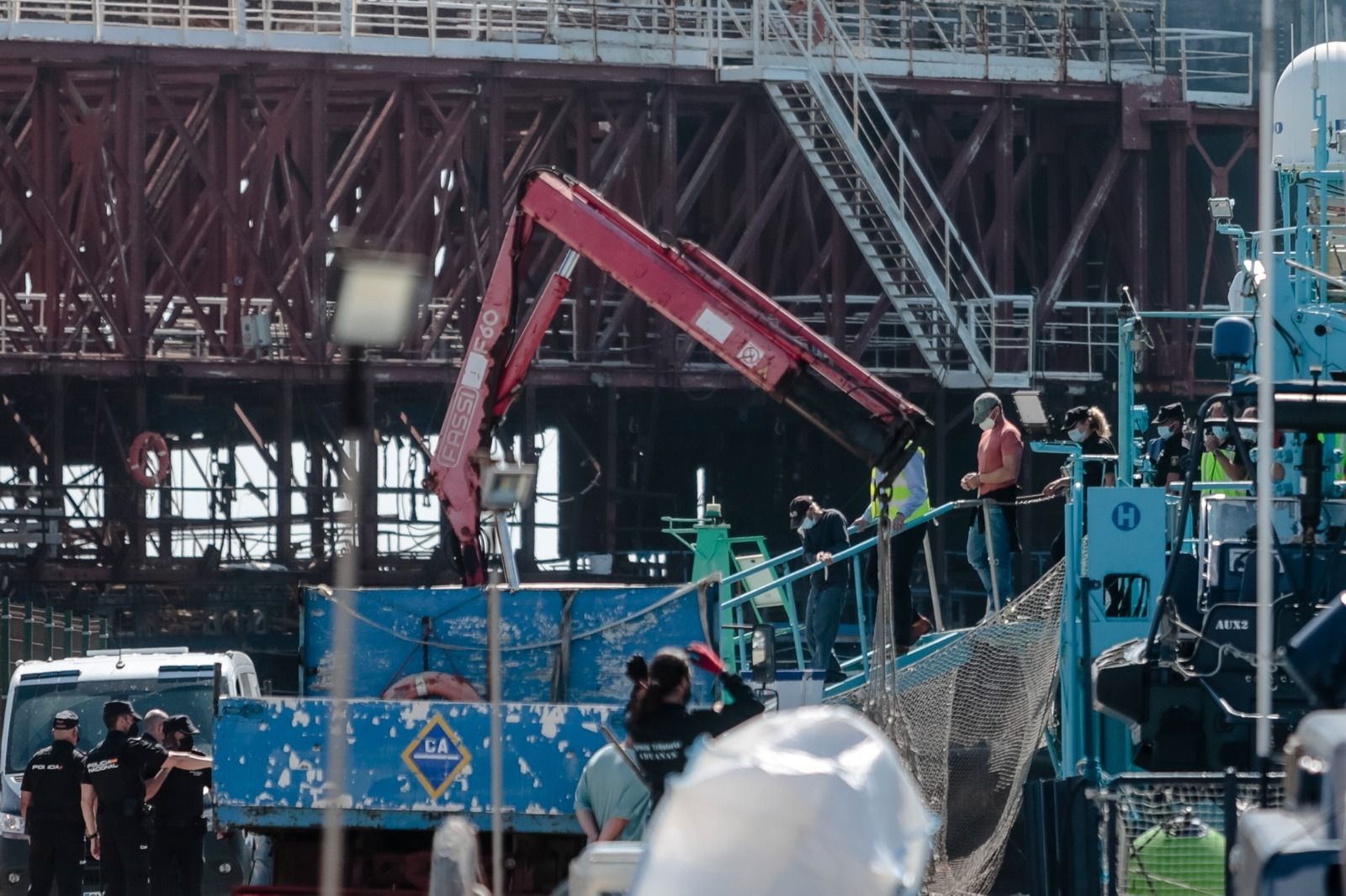 Varios de los detenidos bajan del barco de la Agencia Tributaria.