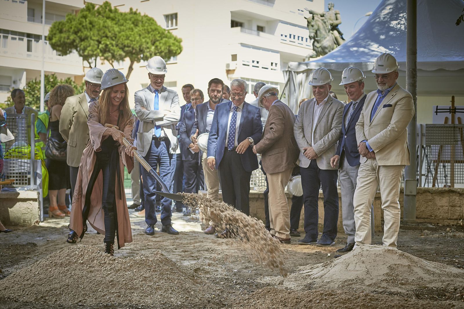 La delegada provincial de Empleo, Gema Pérez, lanza una palada de arena en el acto de inicio de las obras ante la mirada de políticos y cargos de la UCA.