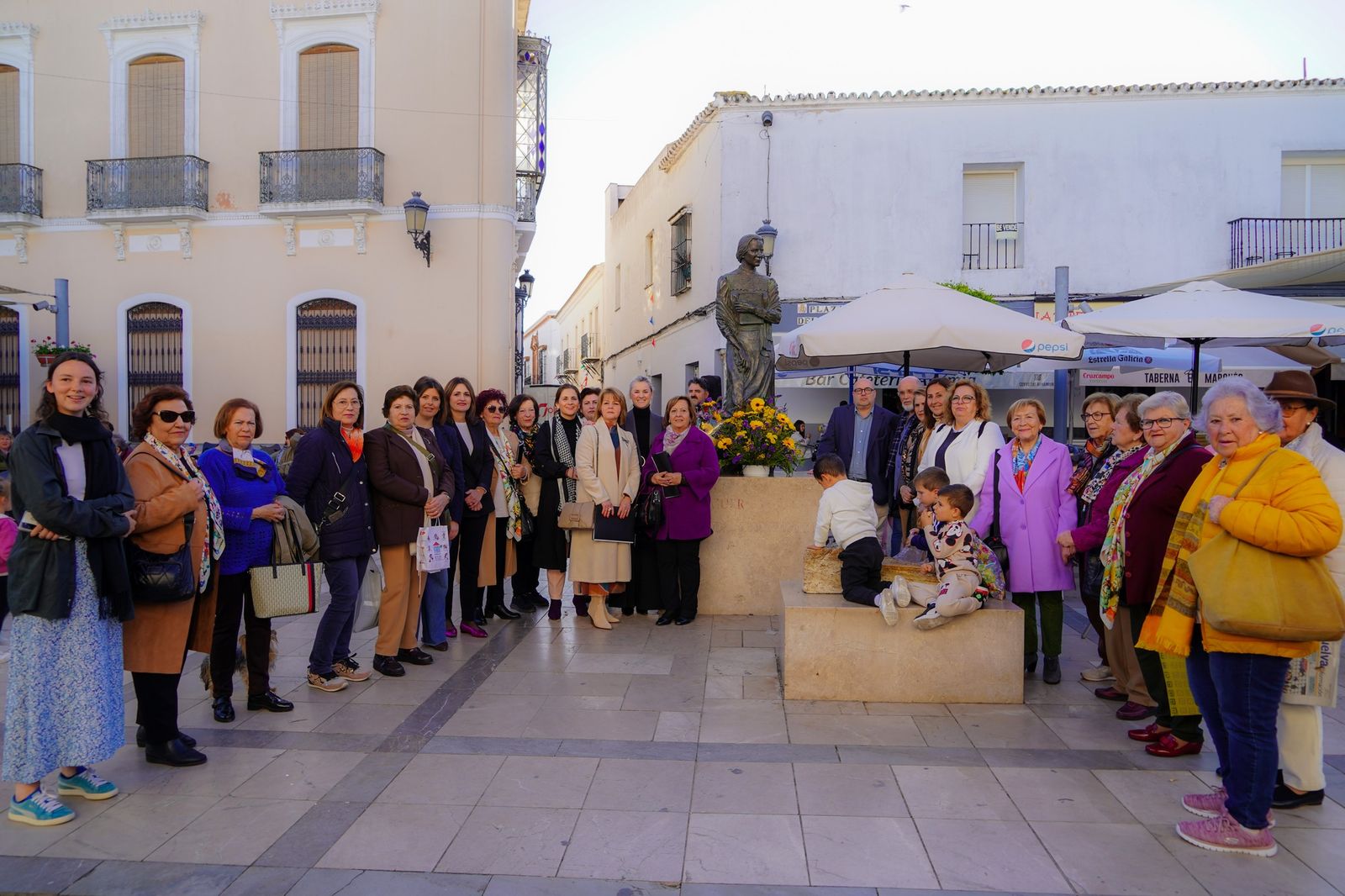 La asociación Zenobia coloca las flores amarillas a los pues de la estatua de la esposa del Nobel.