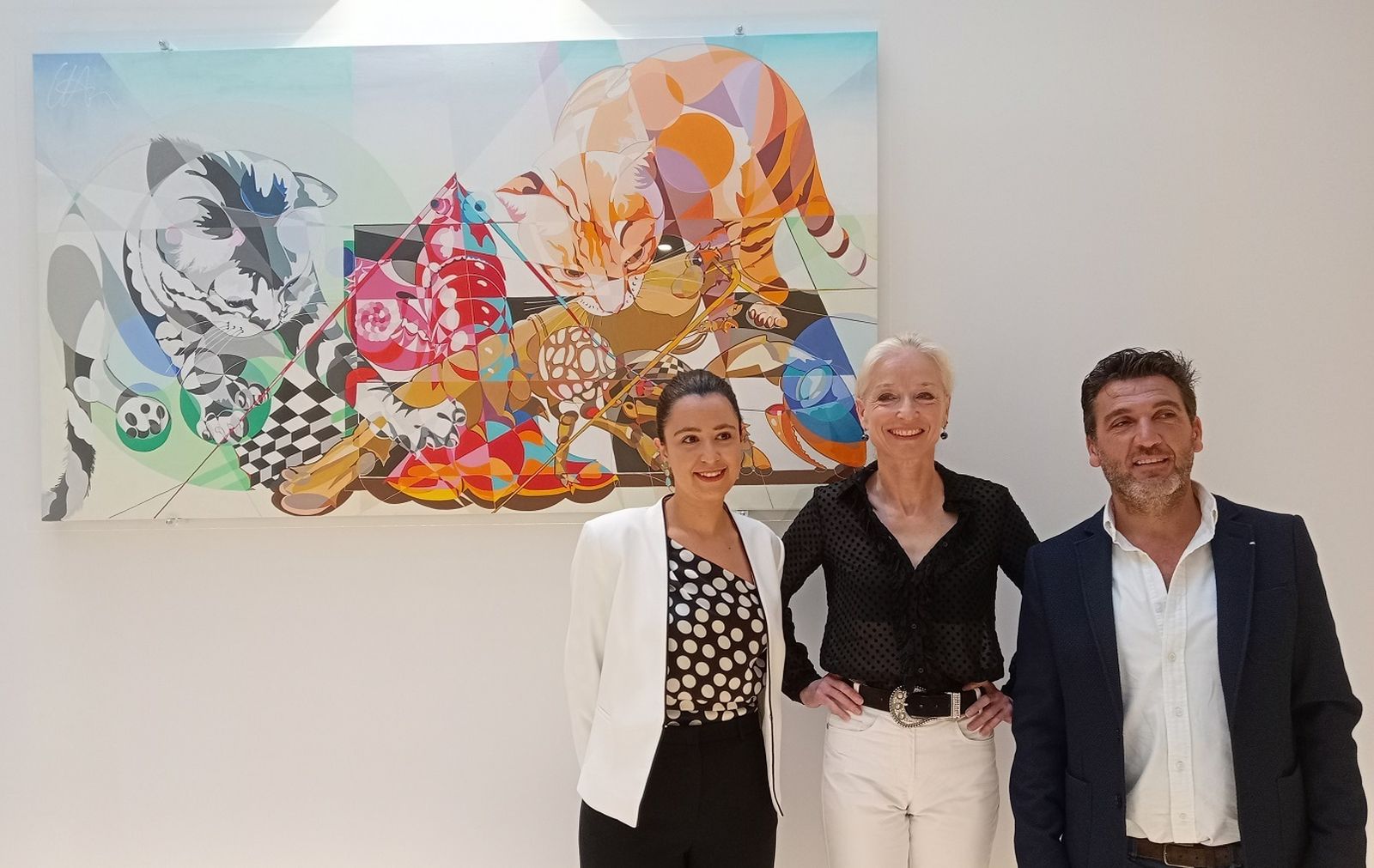 La pintora Uta Geub, con los propietarios de Cisnes Palace en la inauguración de la exposición permanente.