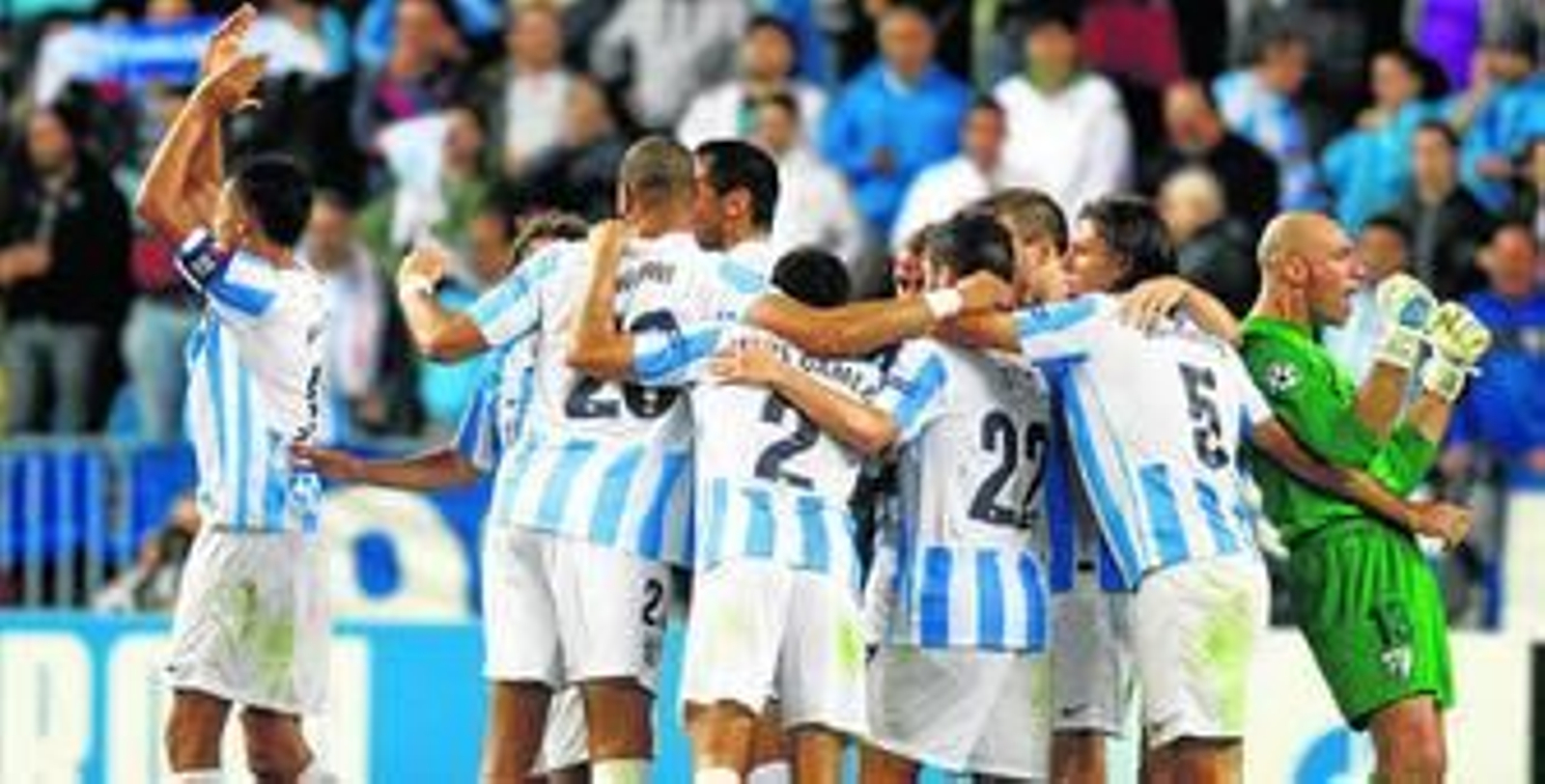 Los jugadores del Málaga forman una piña para celebrar el triunfo ante el Milan.