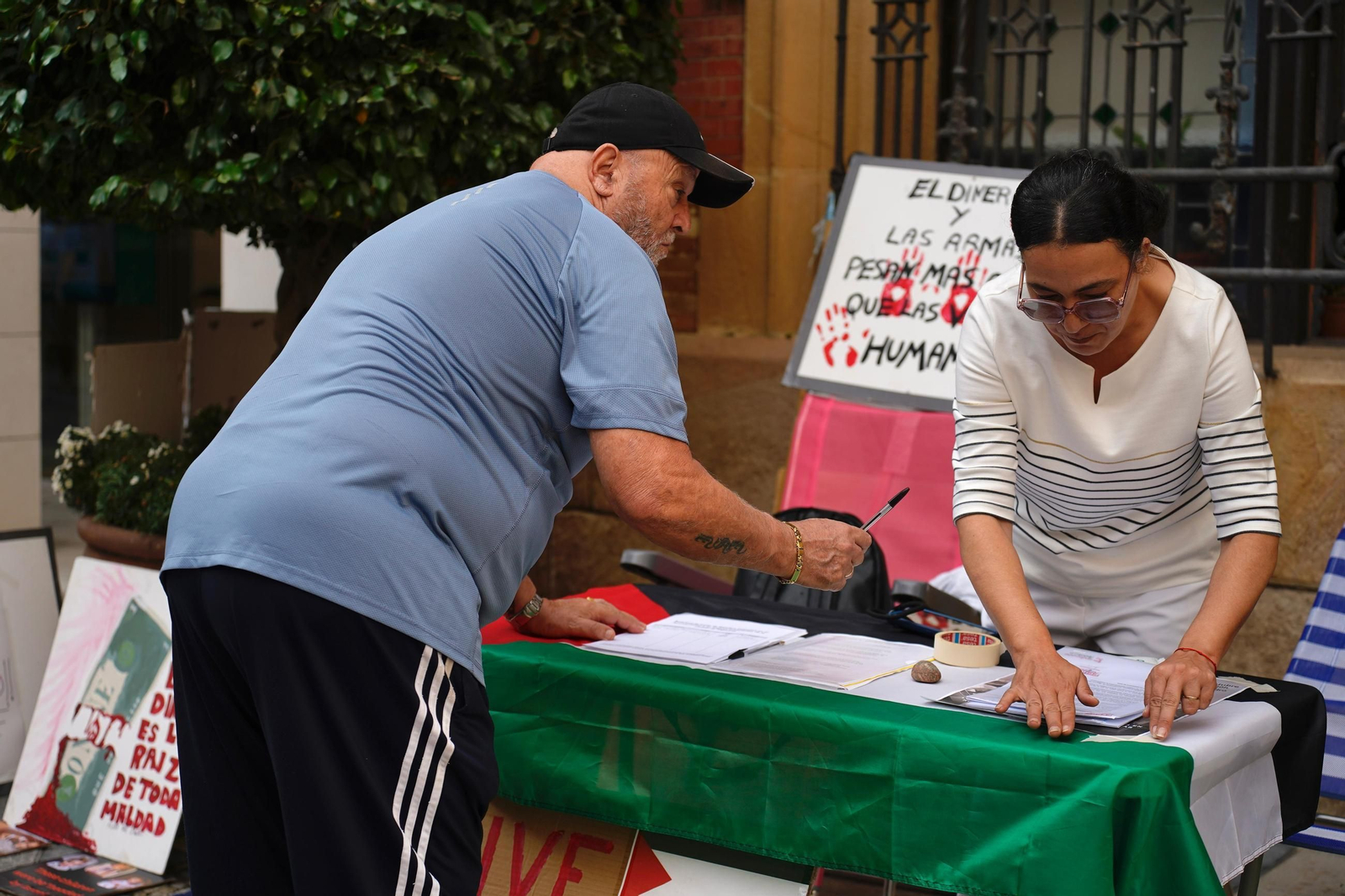 Un hombre, firmando por Palestina.