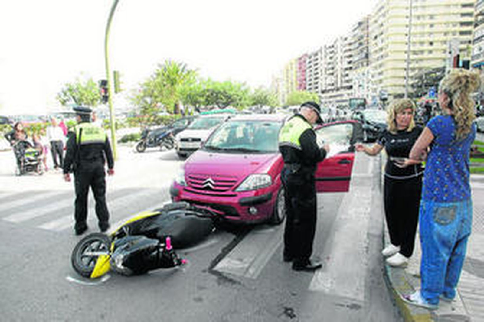 La Policía recoge datos del accidente ante la moto y los dos coches involucrados.